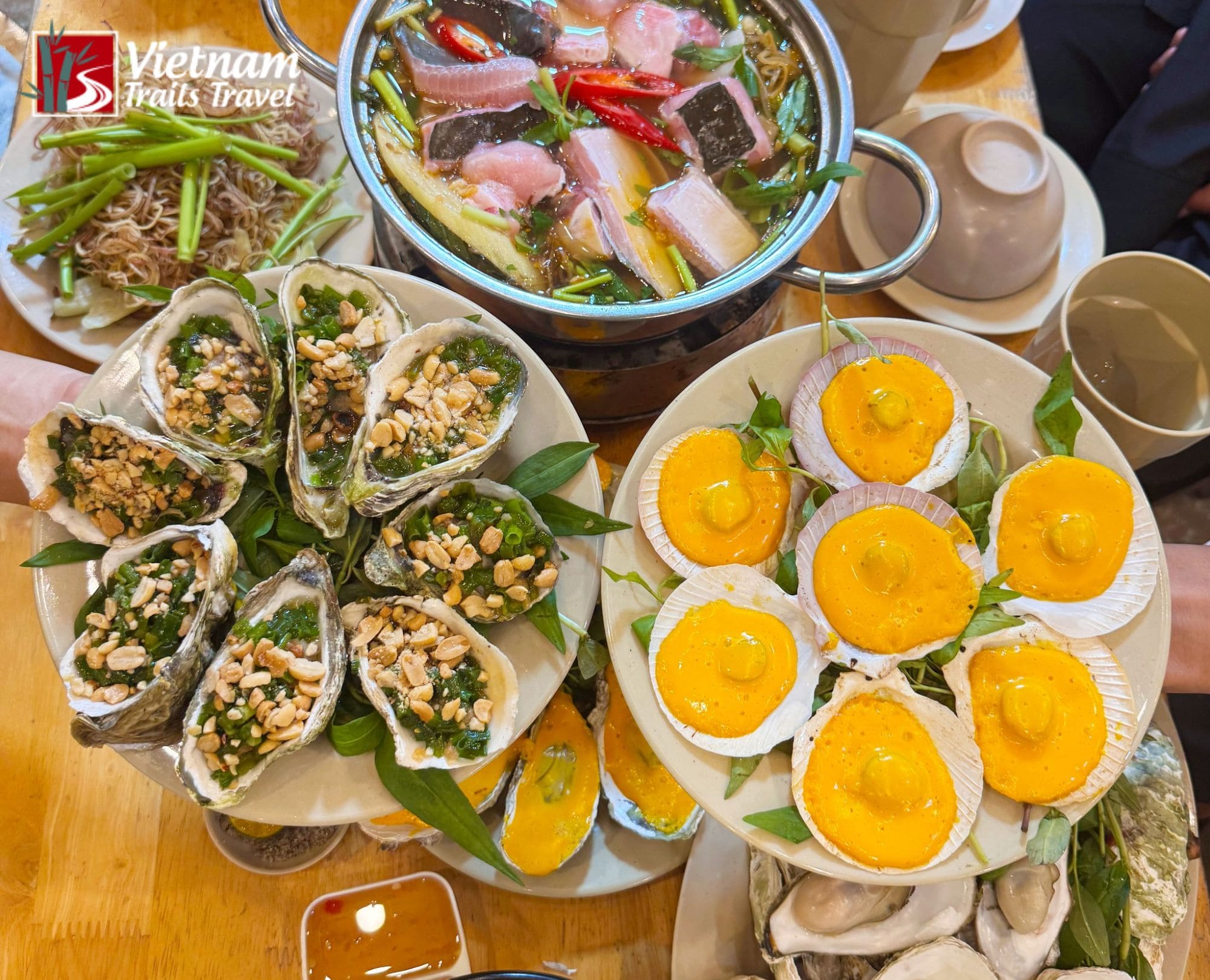 A delicious variety of Saigon street seafood, including grilled oysters with peanuts and scallops in salted egg sauce