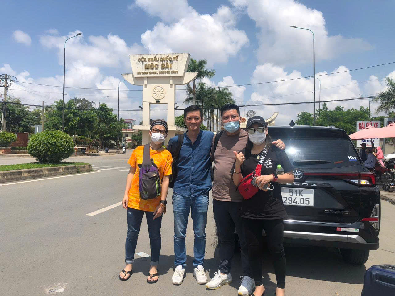 A group of travelers posing in front of the Moc Bai International Border Gate during a visa border run service from Ho Chi Minh City