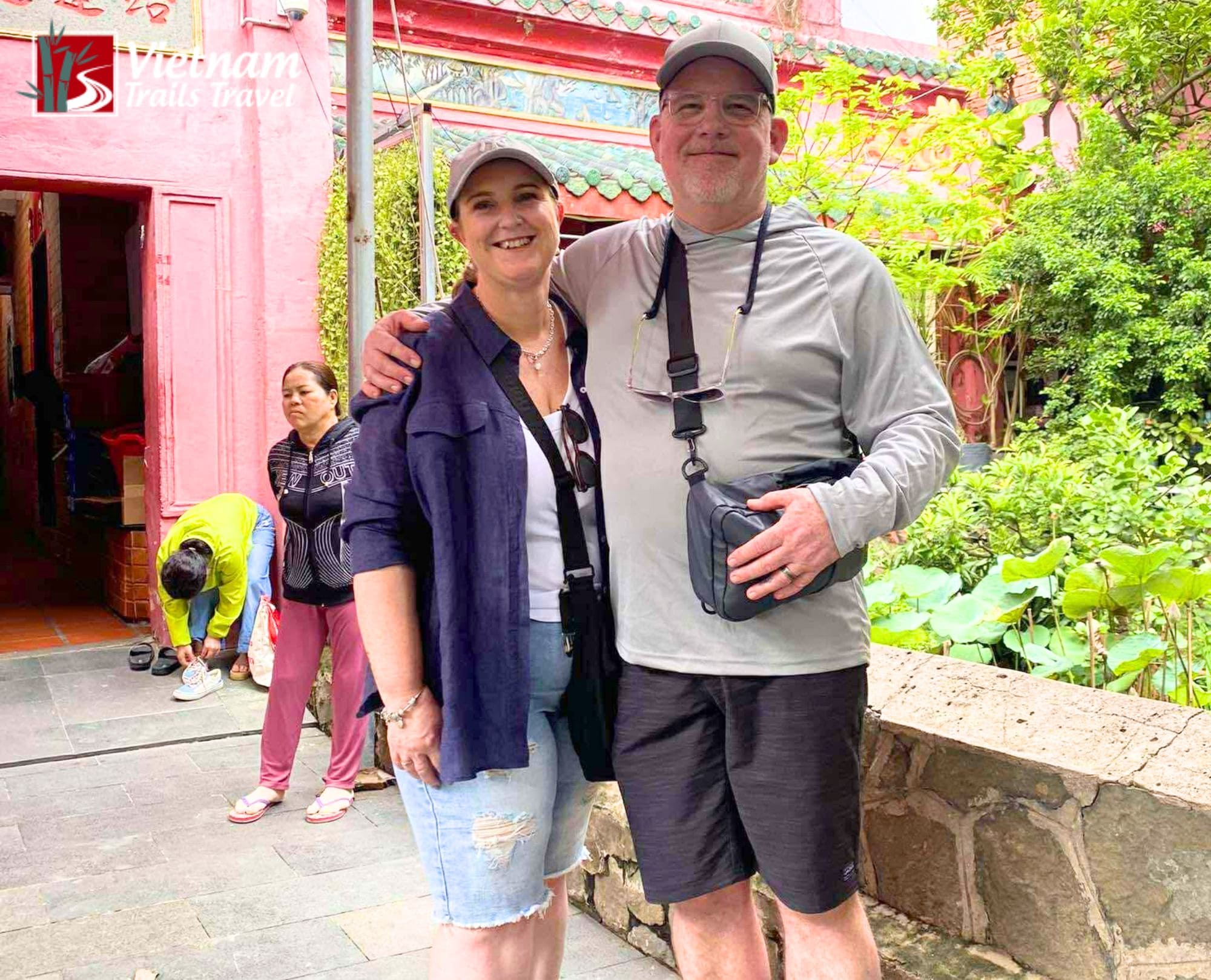 A smiling tourist couple posing together in the courtyard of the Jade Emperor Pagoda