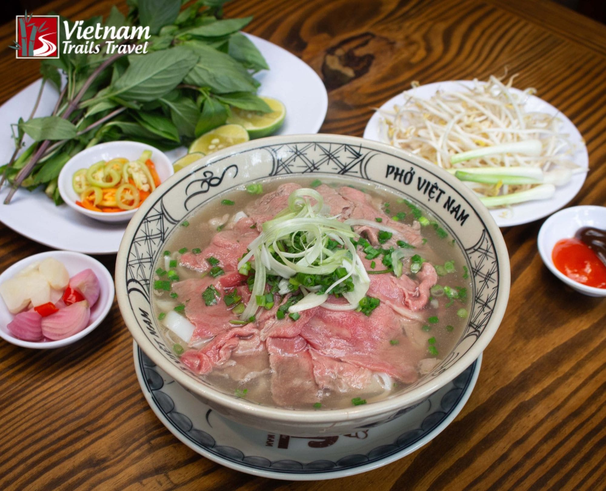 A traditional bowl of Pho Bo (Vietnamese beef noodle soup) served with fresh herbs and bean sprouts