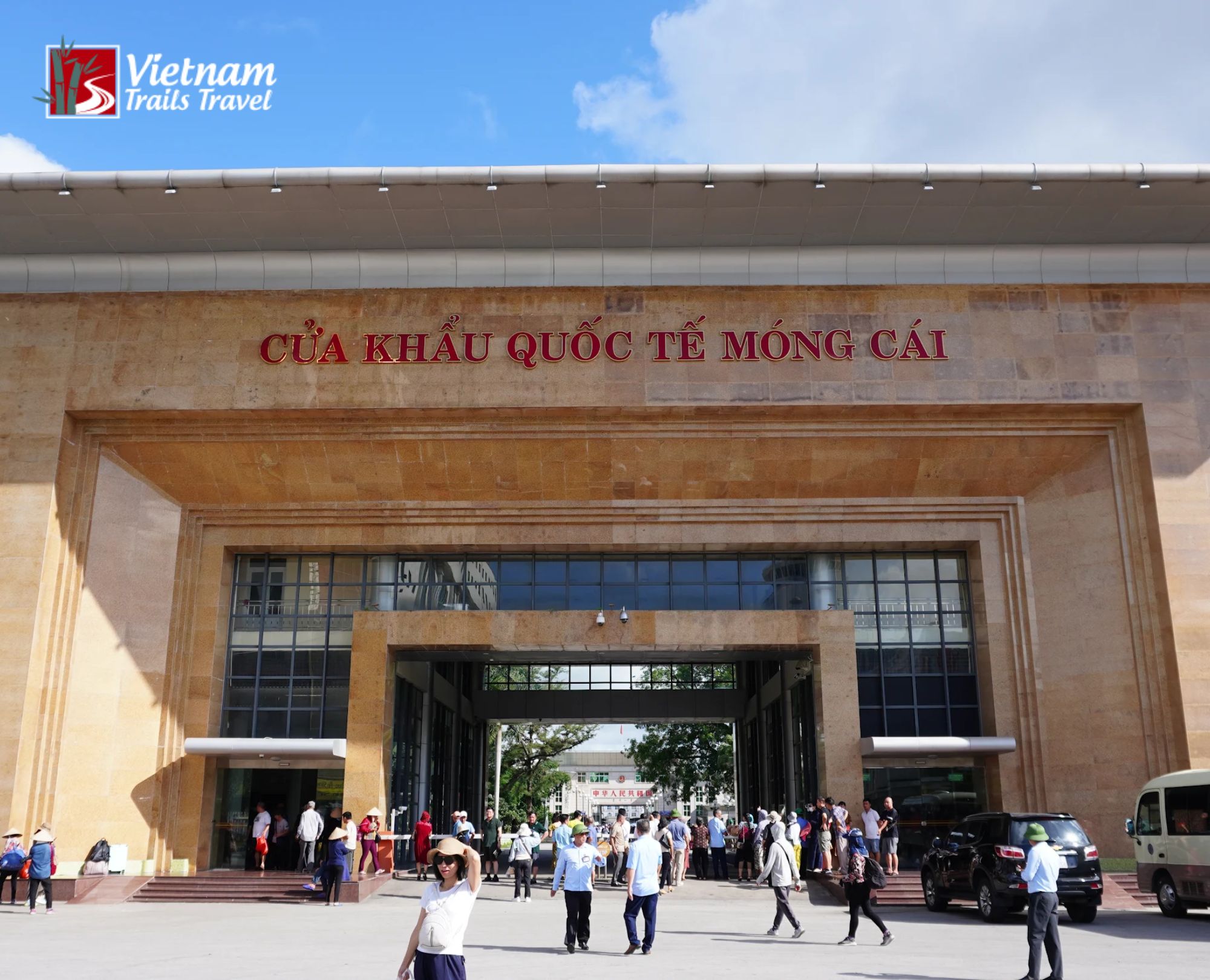 Crowd of visitors and locals outside Mong Cai Border Gate arranging a Vietnam Visa Extension and entry procedures on a sunny day