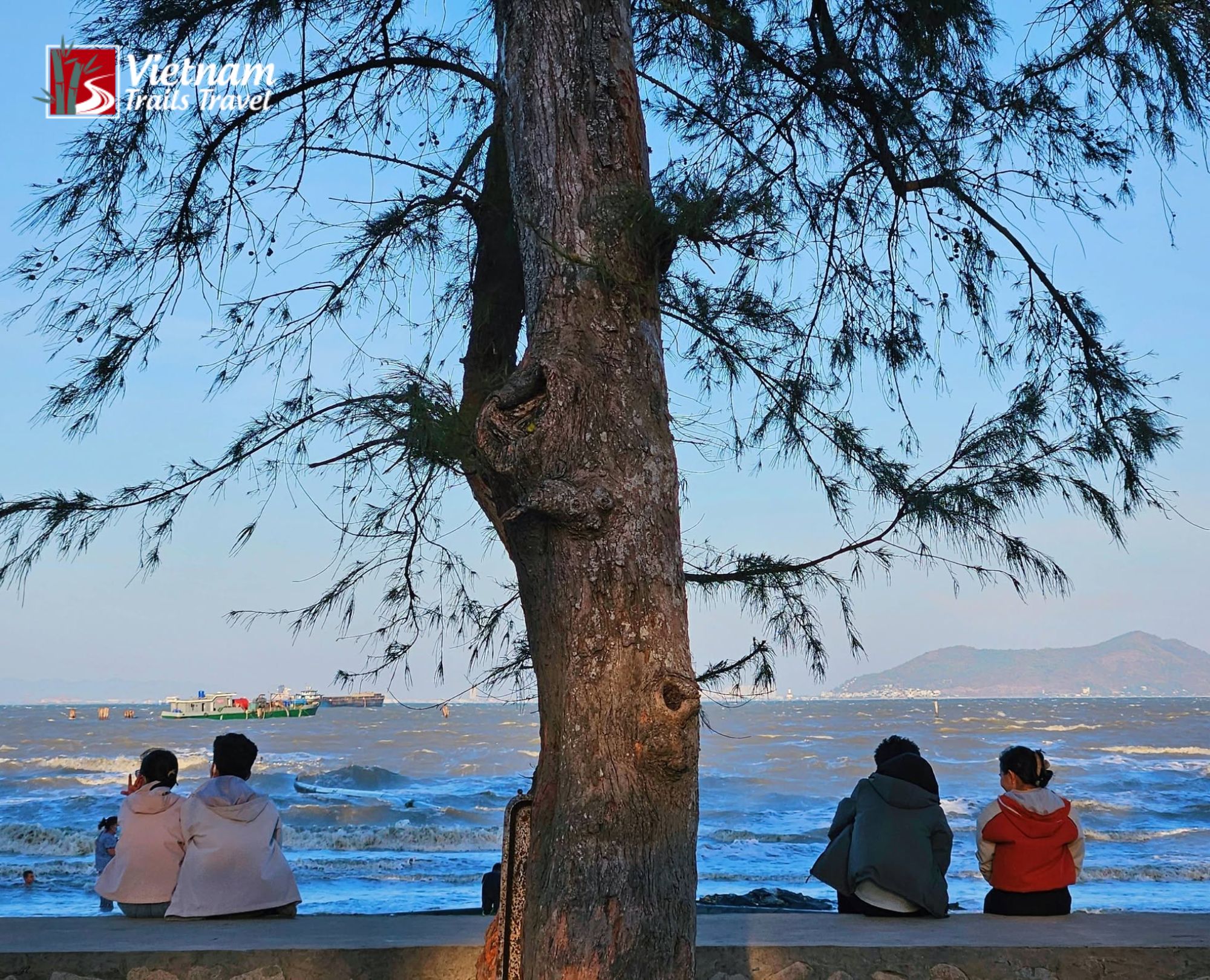 Local residents are sitting on the embankment at Can Gio Beach