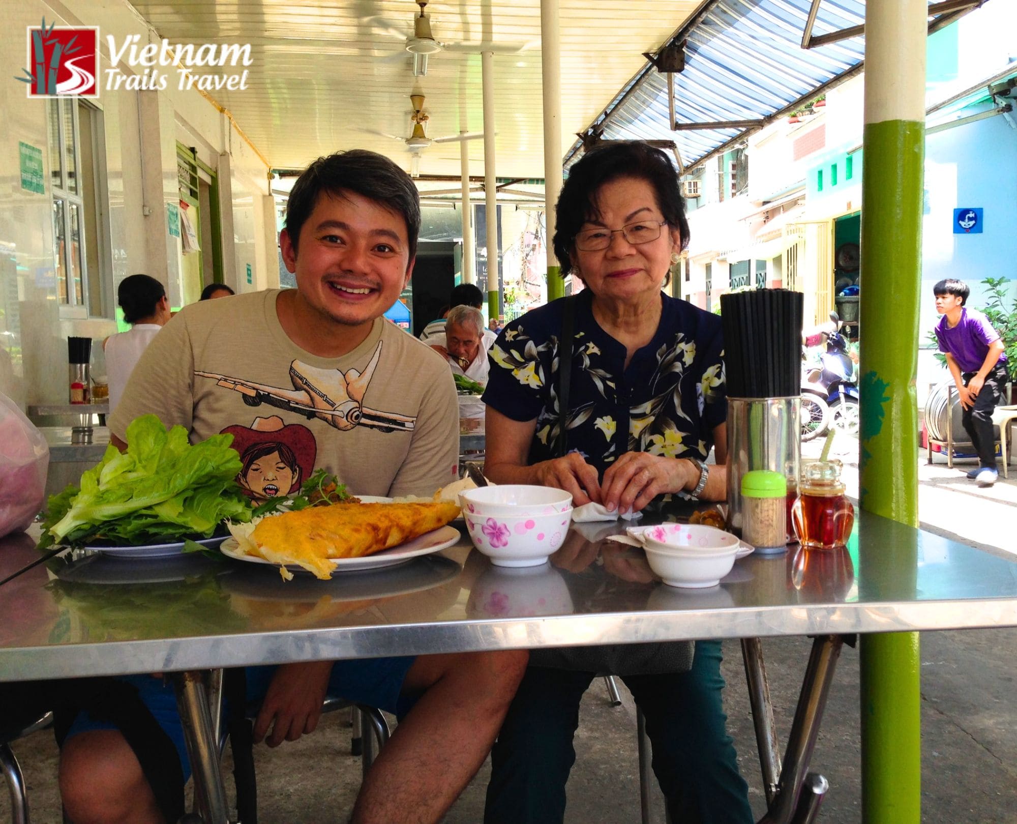 Two tourists are taking a photo before trying banh xeo in District 1