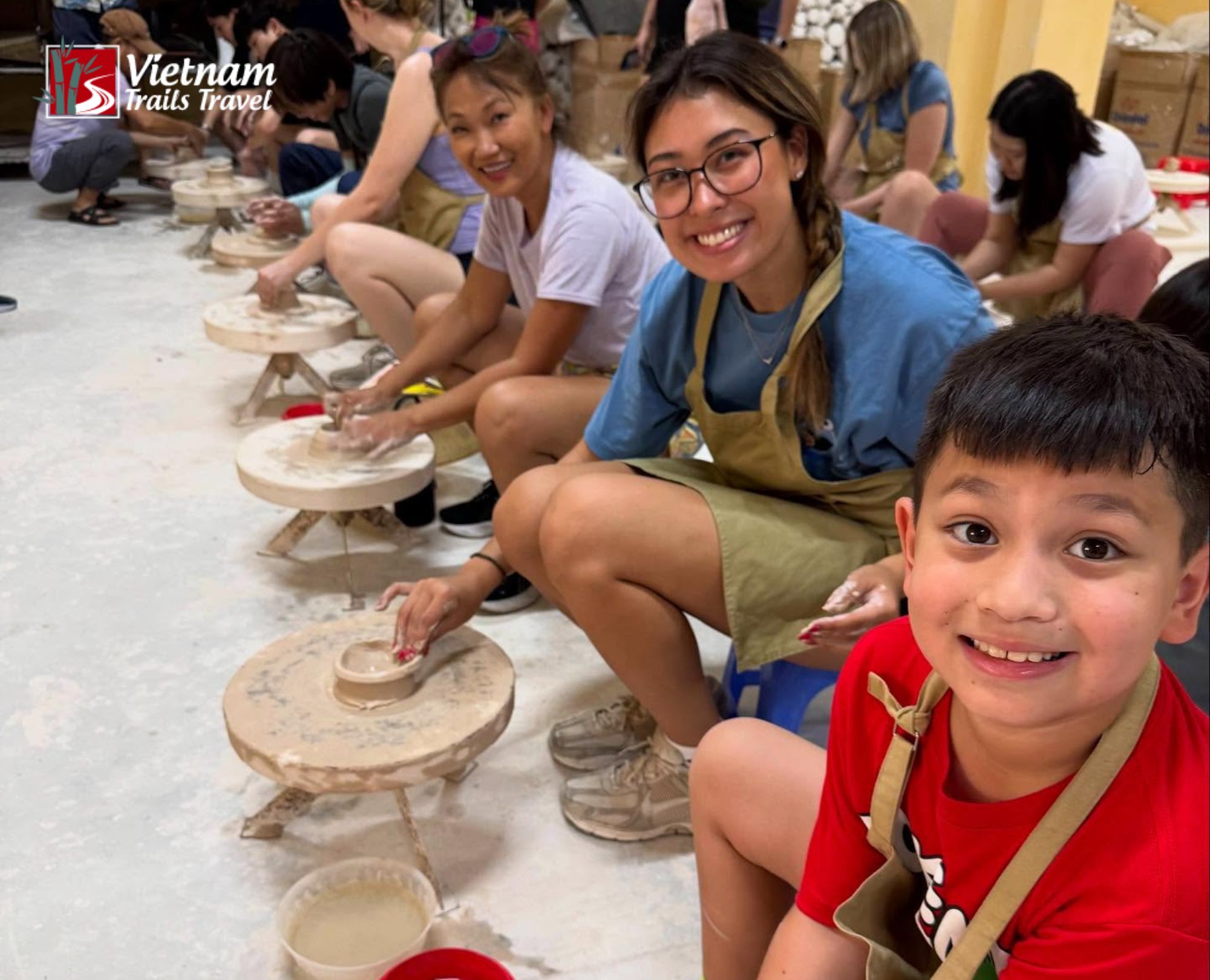 A Singaporean tourist family is making pottery at Bat Trang pottery village