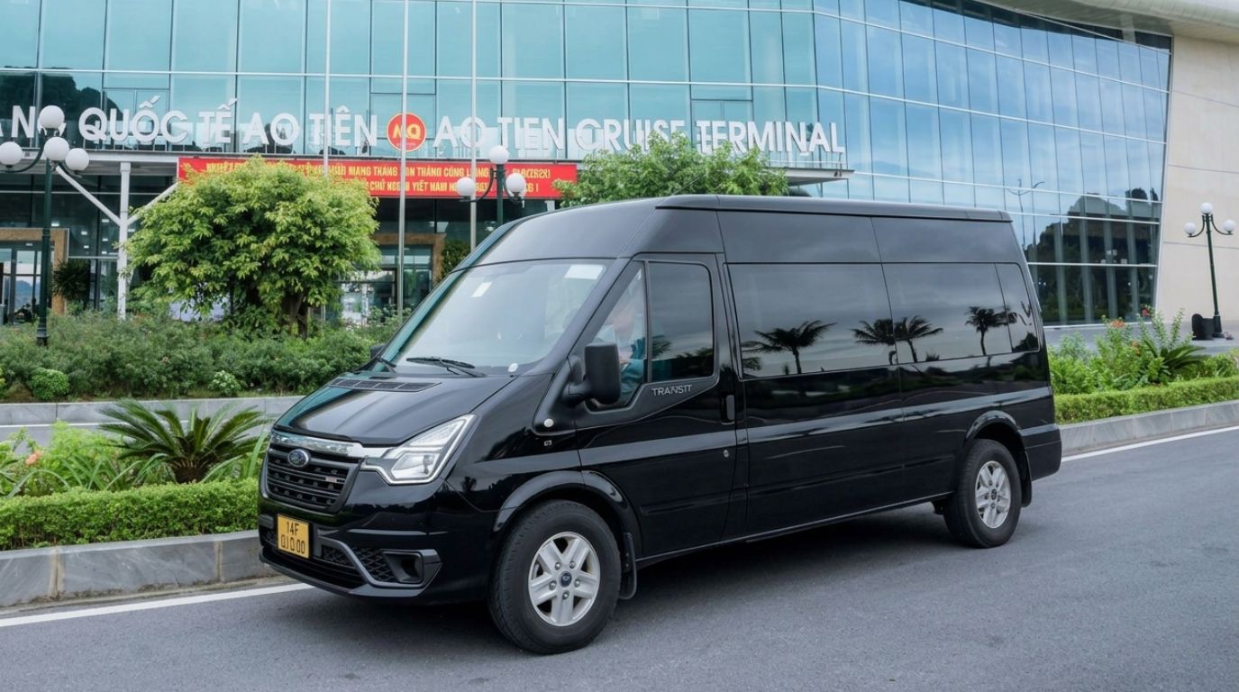 A black luxury transit van parked in front of the modern Ao Tien Cruise Terminal for passenger transfers
