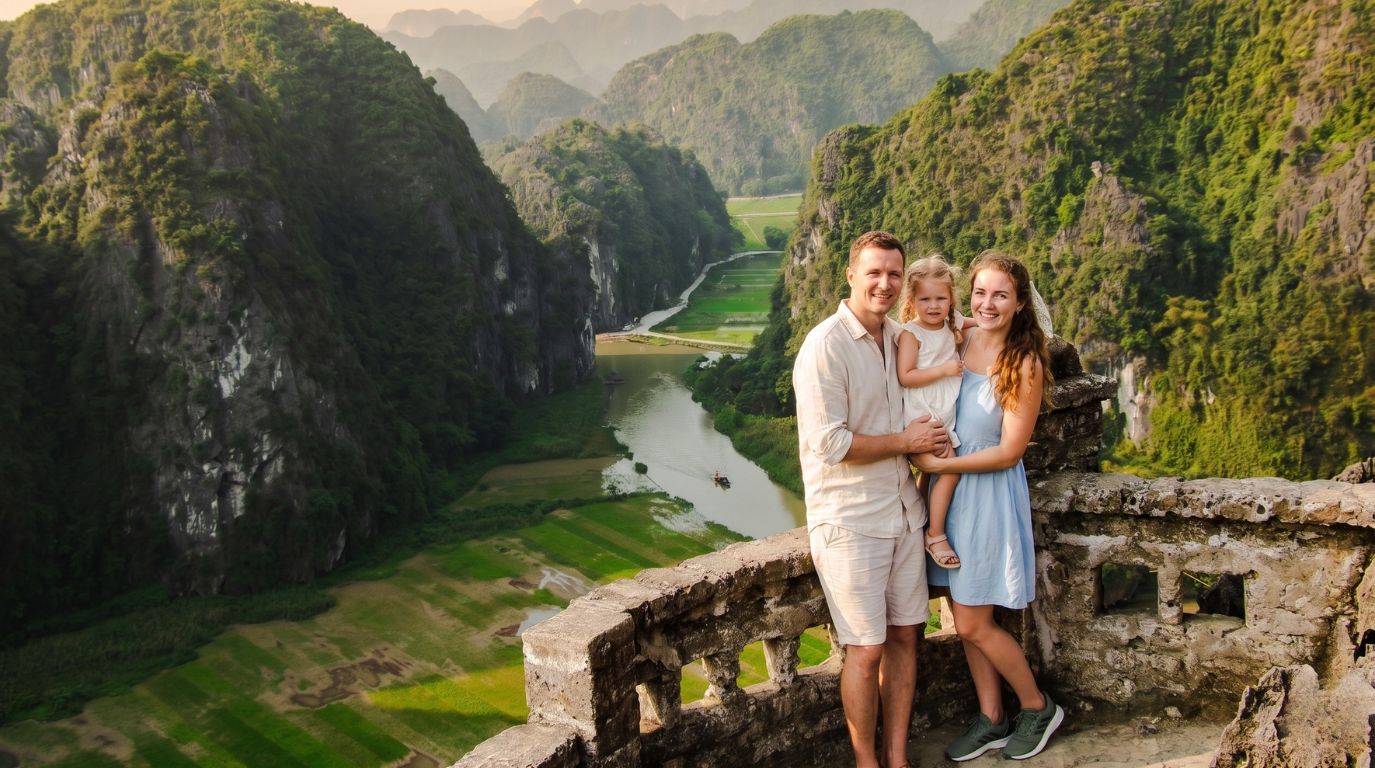 A family posing at the Hang Mua viewpoint, enjoying a breathtaking panoramic view of the Tam Coc river and mountains