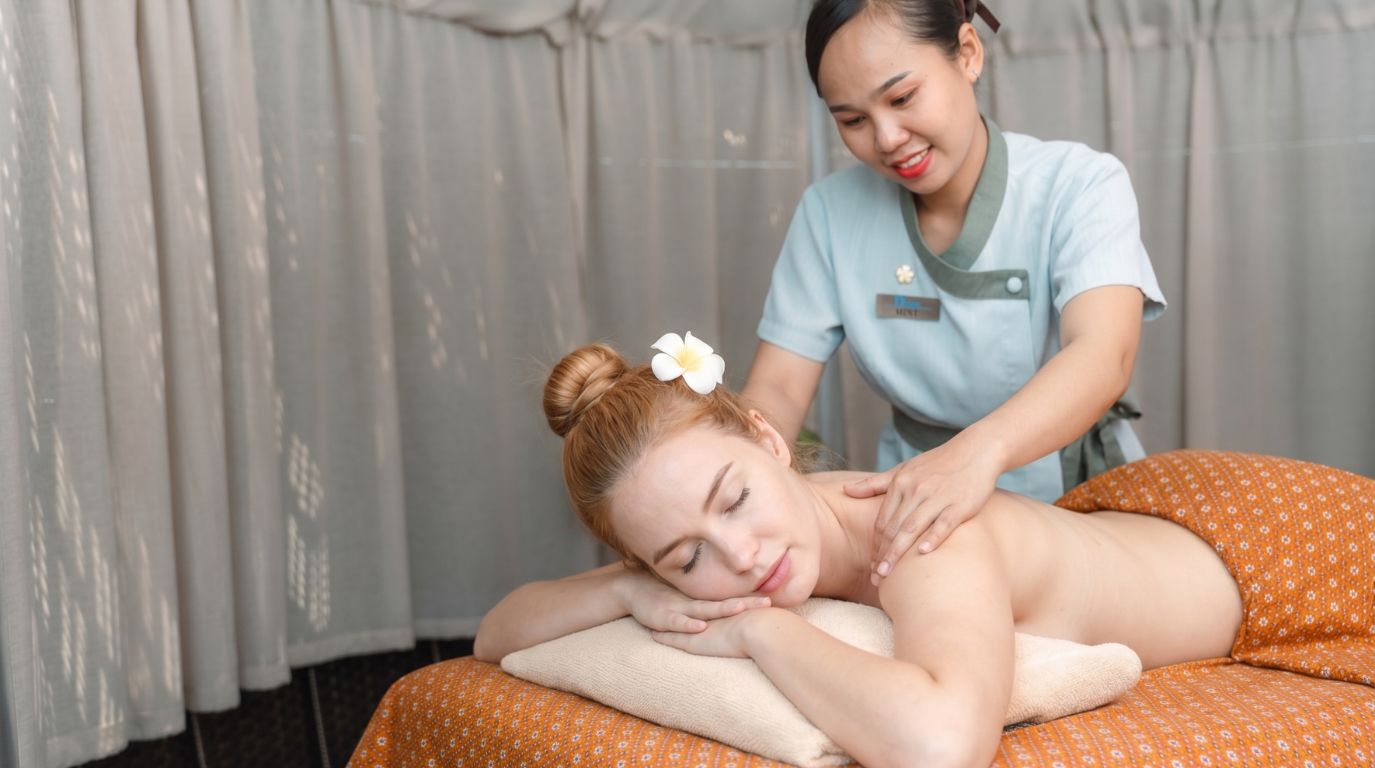 A female tourist enjoying a relaxing traditional massage treatment at a wellness spa center