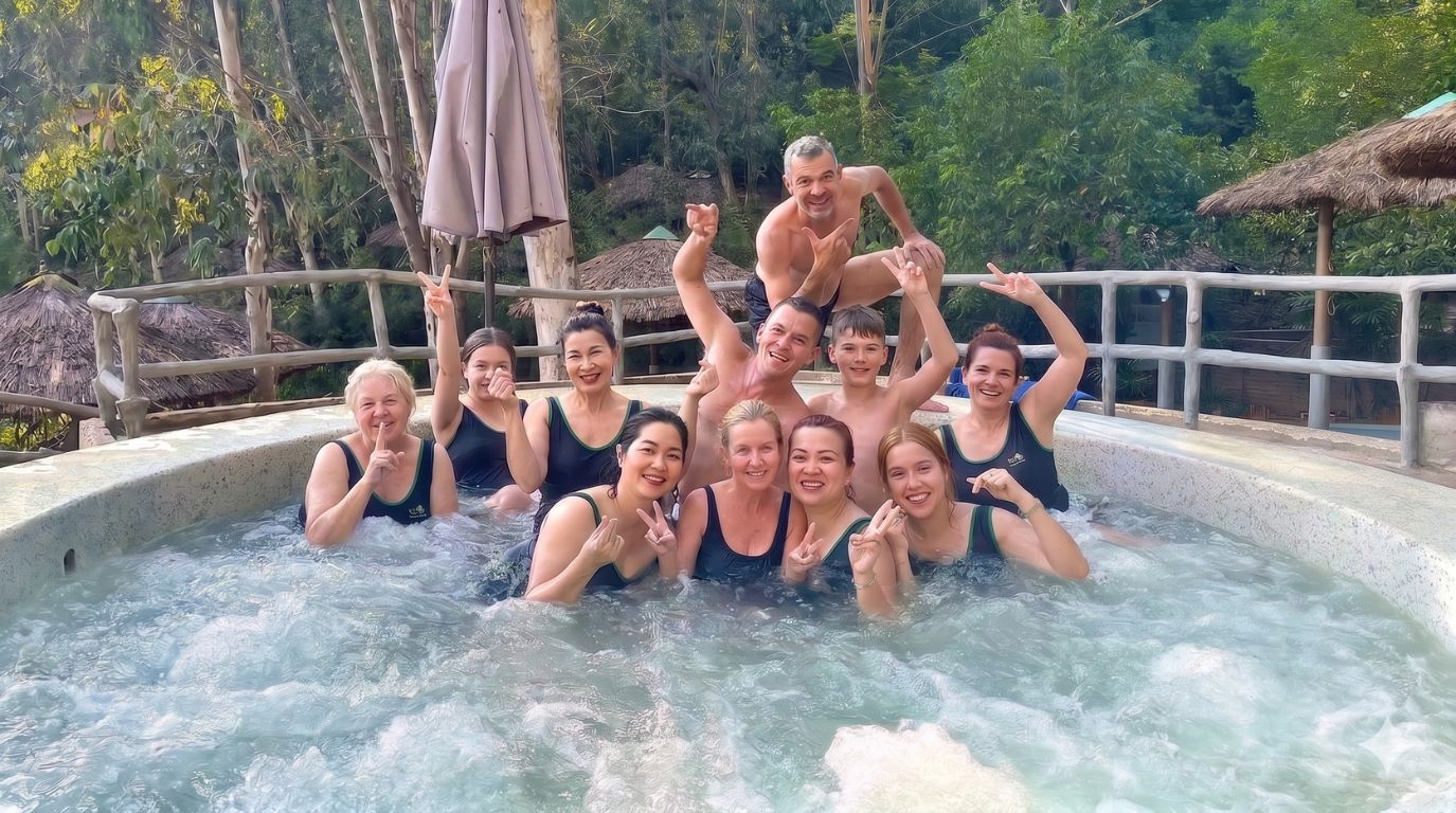 A group of happy tourists relaxing together in a mineral hot spring mud bath at a tropical resort in Nha Trang 
