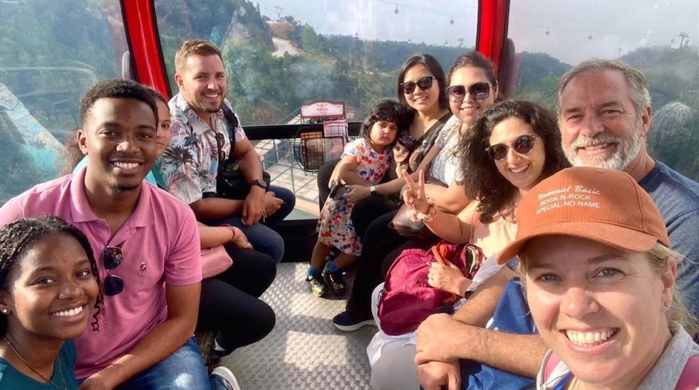 A group of happy tourists riding the Sun World Ba Na Hills cable car with scenic forest views in Da Nang