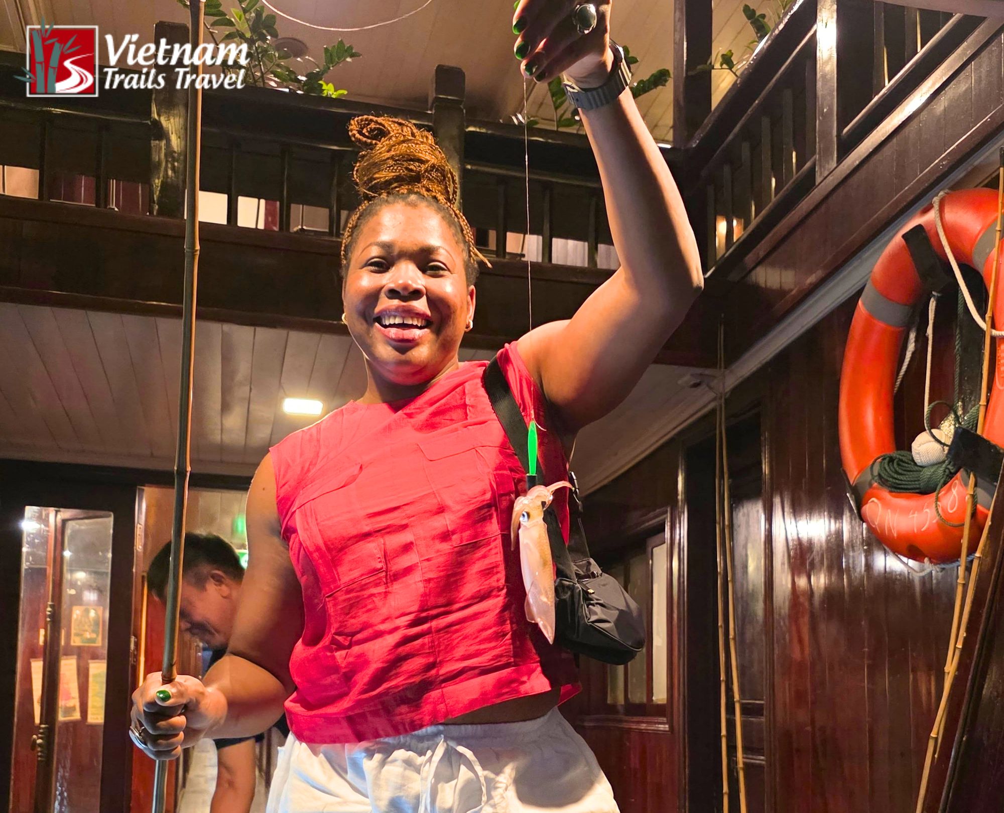 A woman tourist squid fishing at night on the Indochine Sails Cruise in Ha Long Bay