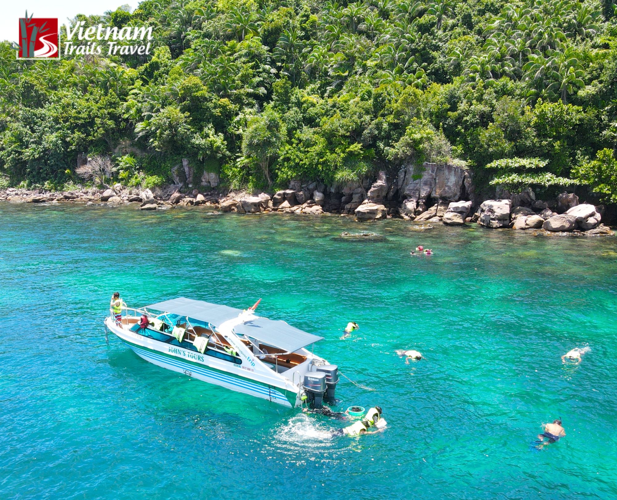 Aerial view of Vietnam Trails Travel speedboat and snorkelers exploring coral reefs in An Thoi archipelago