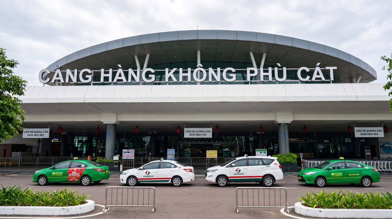 Exterior view of the Phu Cat Airport terminal building with waiting taxis in Quy Nhon