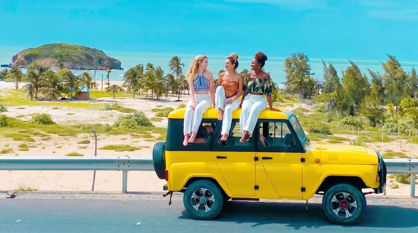 Friends experiencing the famous coastal Jeep tour in Mui Ne with beautiful ocean and island backdrops