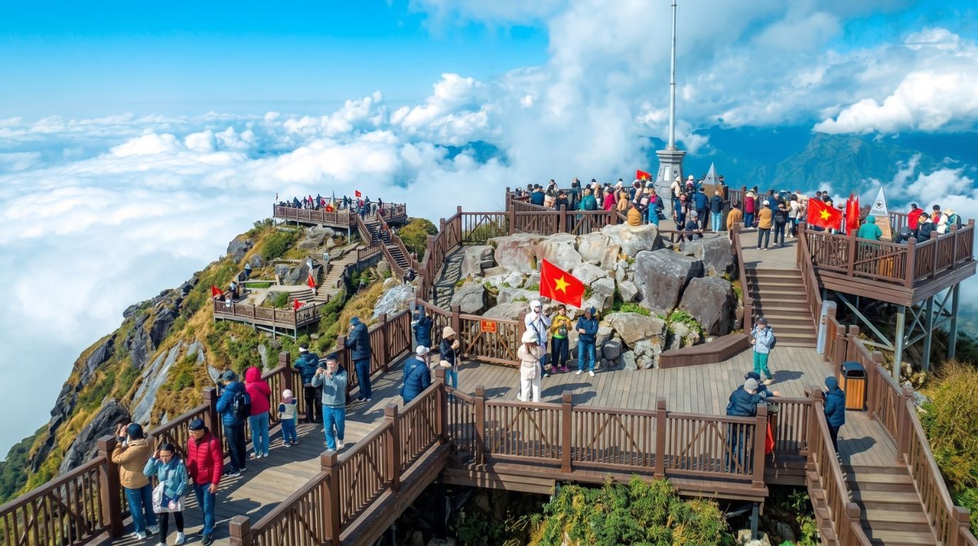 Tourists enjoying the spectacular sea of clouds from the wooden observation deck at the summit of Fansipan Peak in Sapa