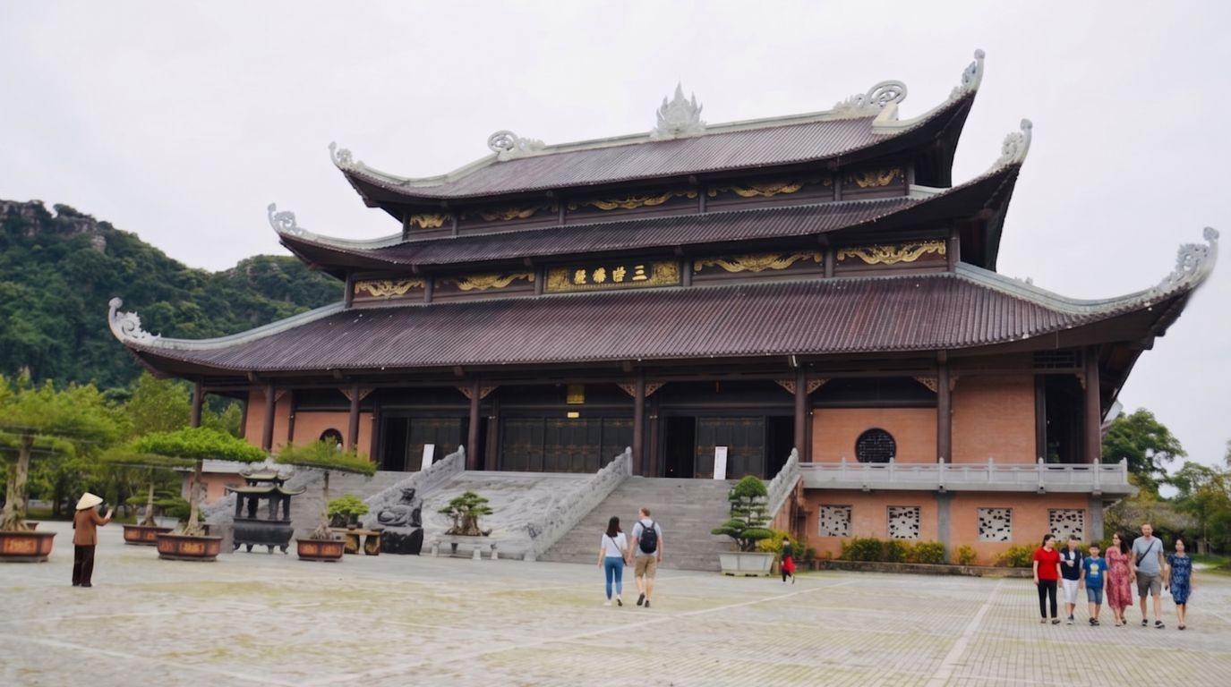 Tourists walking in the spacious courtyard of the majestic Bai Dinh Pagoda complex in Ninh Binh