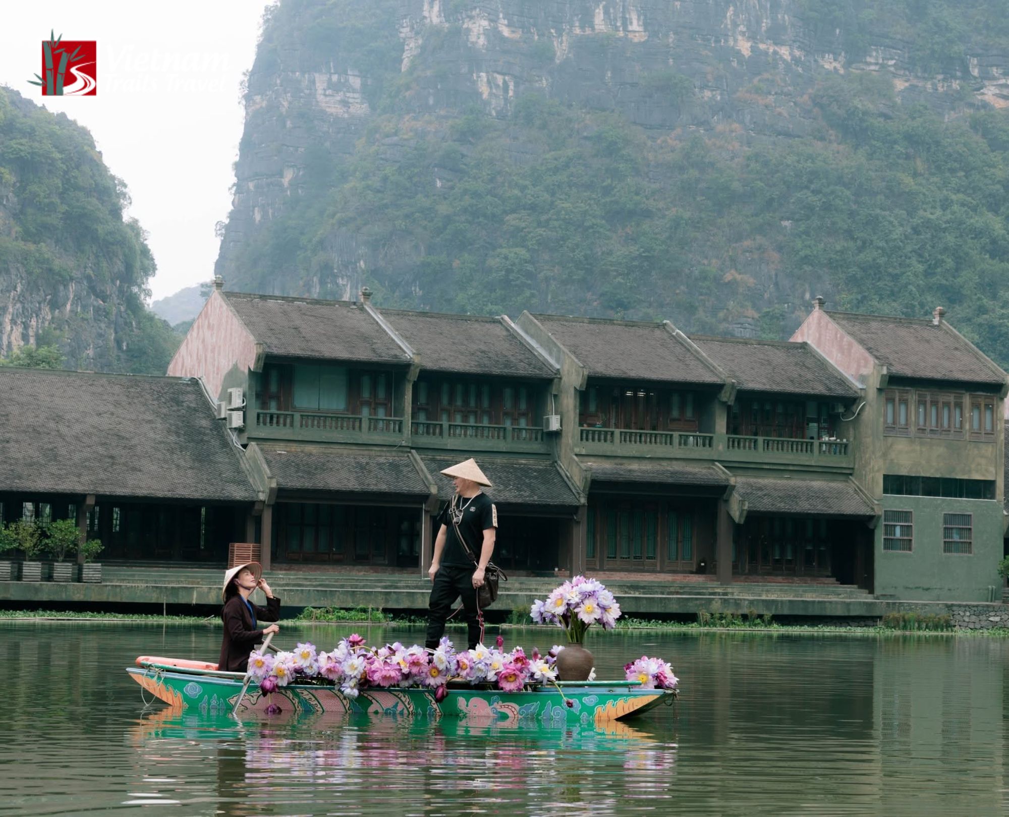 Trang An landscape with rowboat floral decor and limestone mountain backdrop