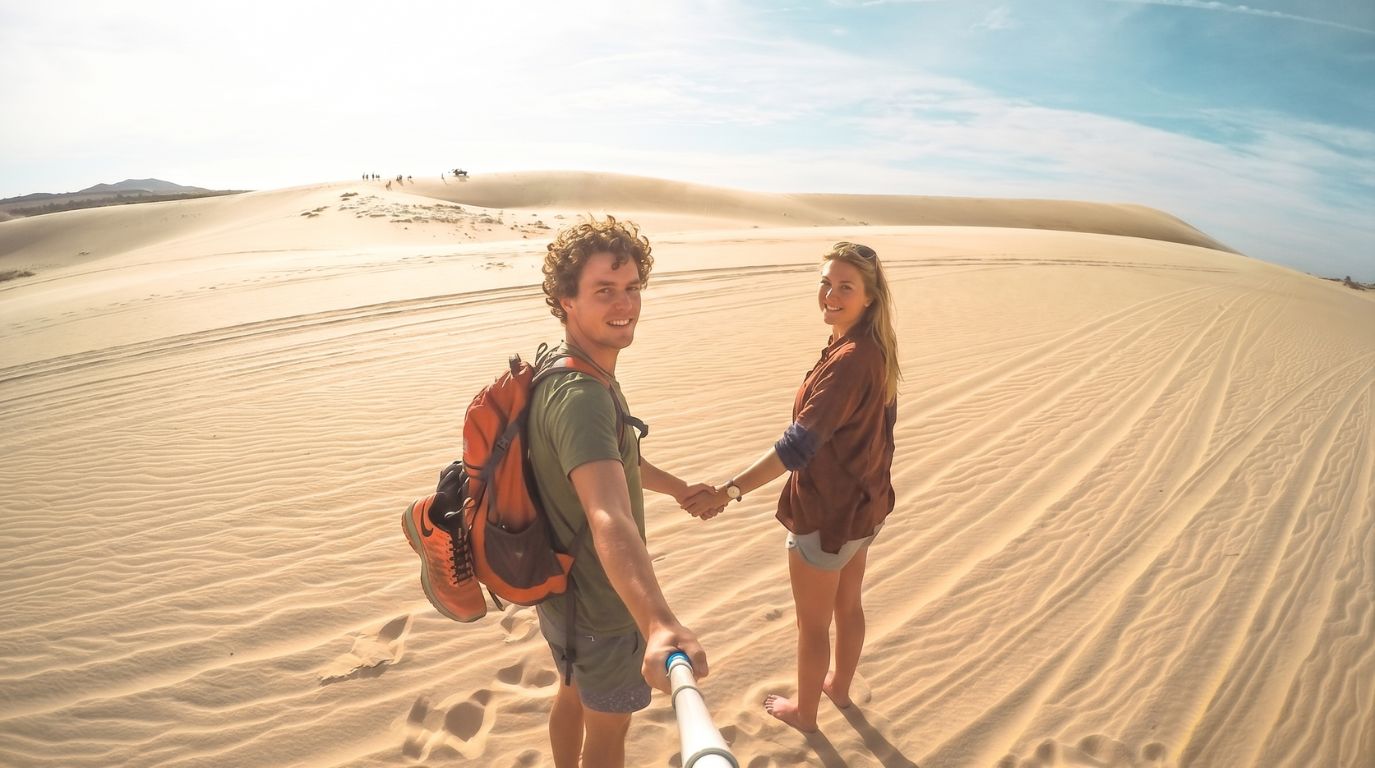 Travelers capturing a fun selfie at the famous White Sand Dunes (Bau Trang) in Mui Ne, Vietnam's mini desert