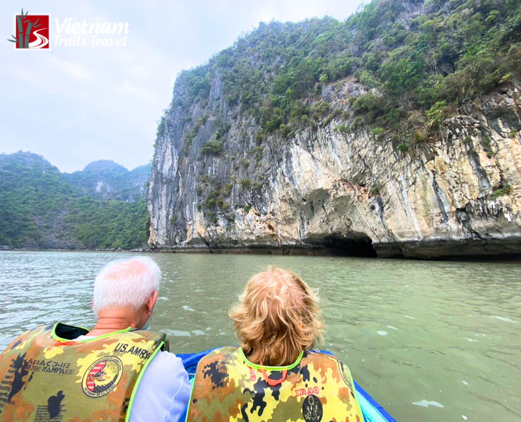 Travelers paddling blue sampan to explore dark cave
