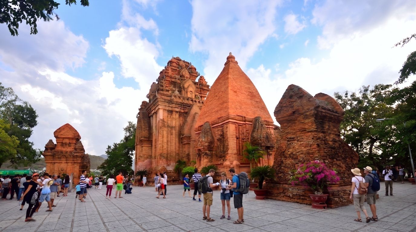 Visitors exploring the ancient red brick Po Nagar Cham Towers, a famous historical and cultural landmark in Nha Trang