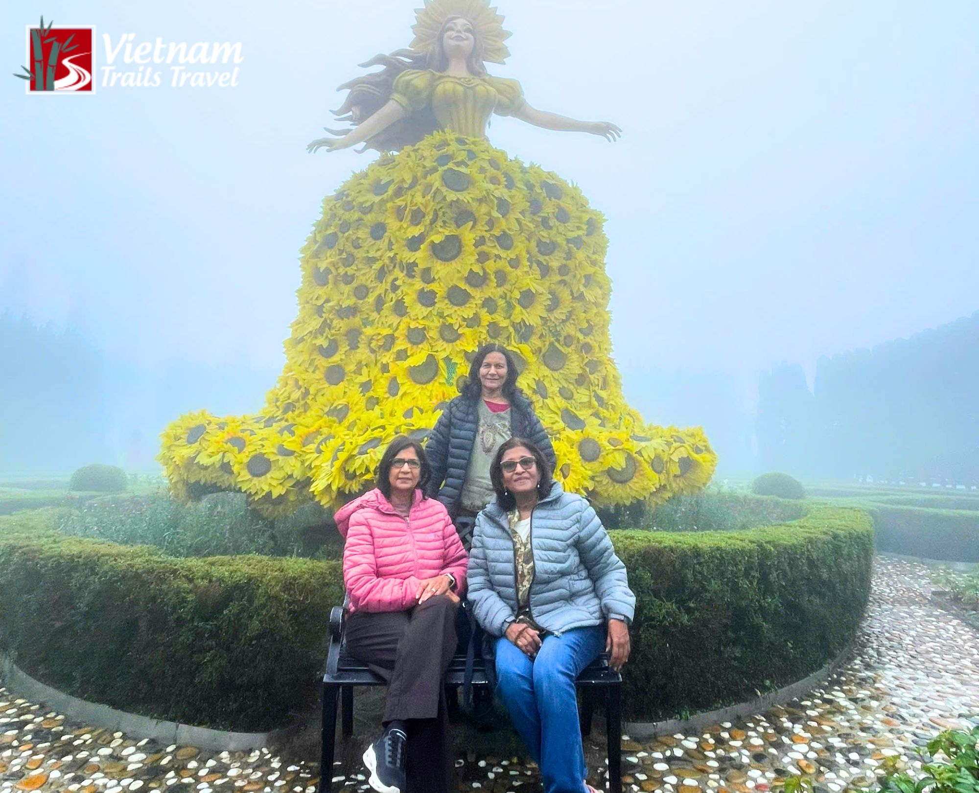 Tourists posing in front of the iconic sunflower sculpture at Le Jardin d'Amour garden