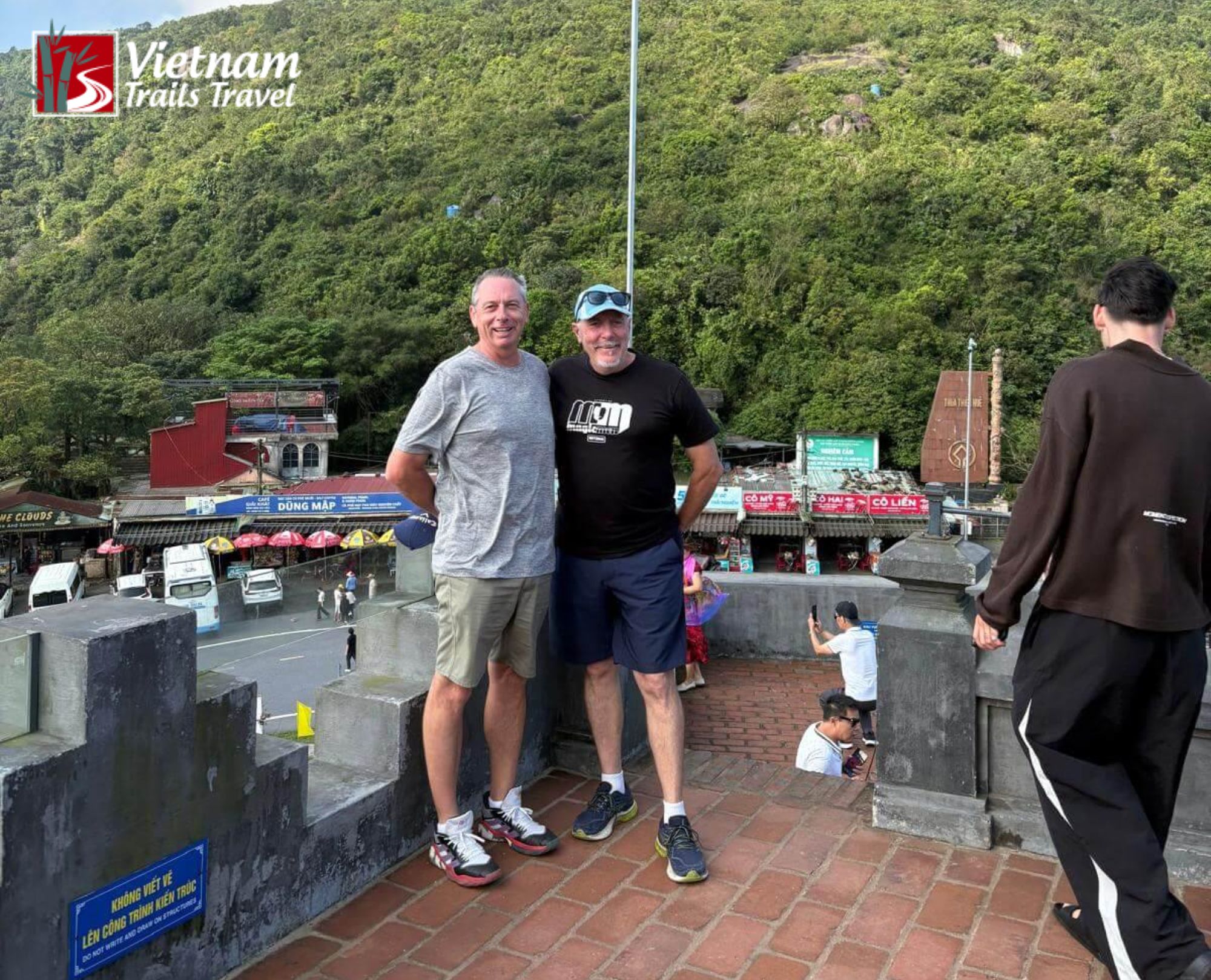 Travelers at Hải Vân Pass gateway with scenic forested hills and cloudy sky