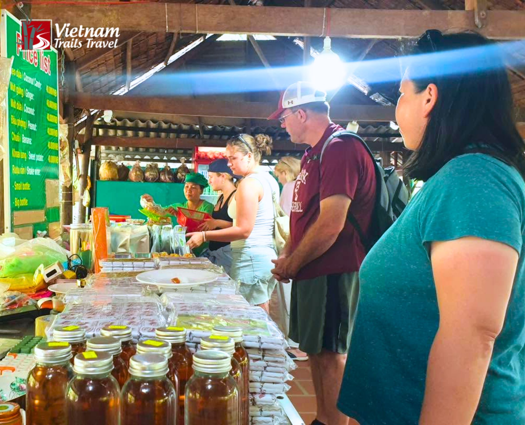 Travelers sampling and buying coconut candies and local goods at a shop