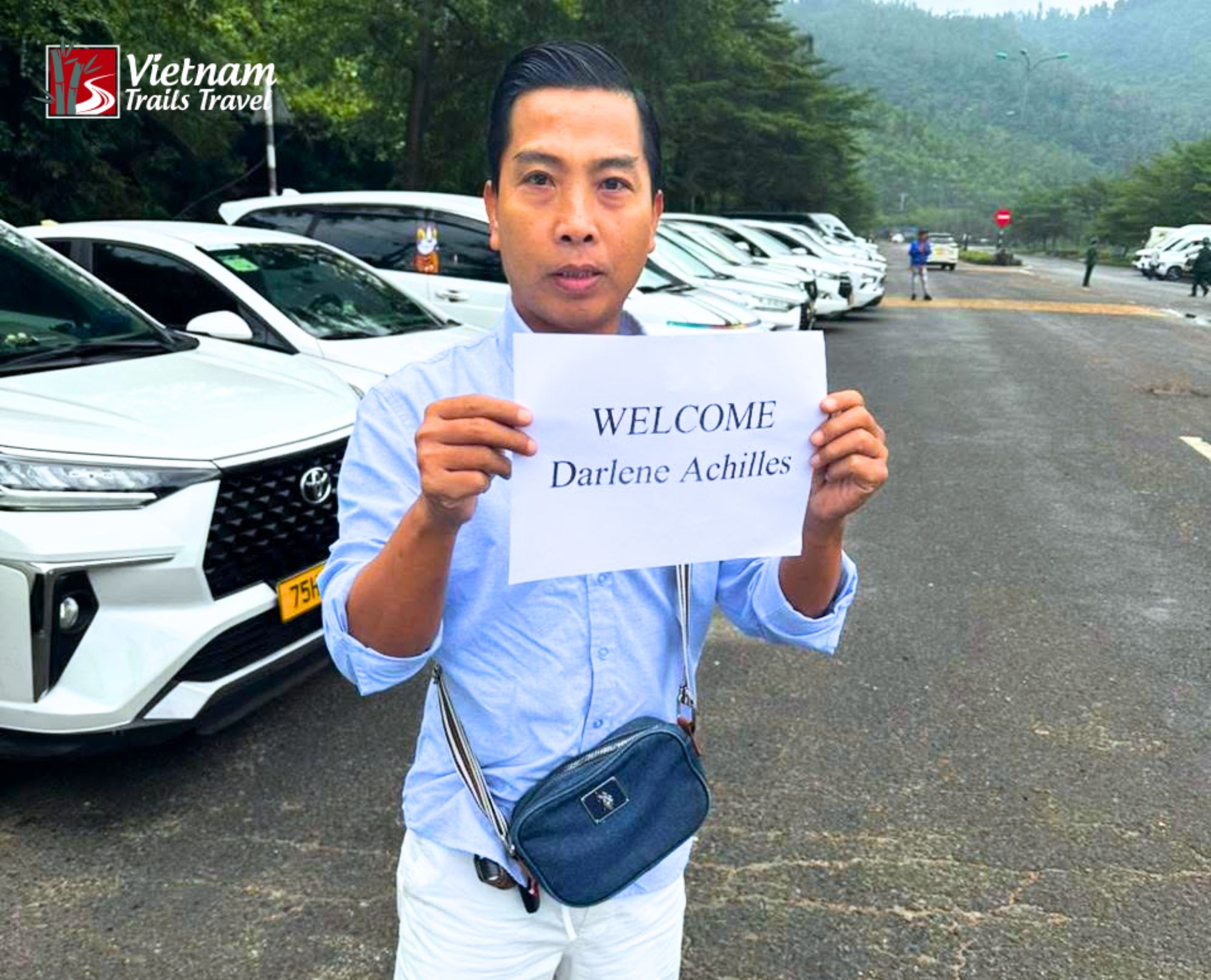 A tour guide holding a welcome sign at Chan May Port greeting cruise passengers arriving for a Danang day tour