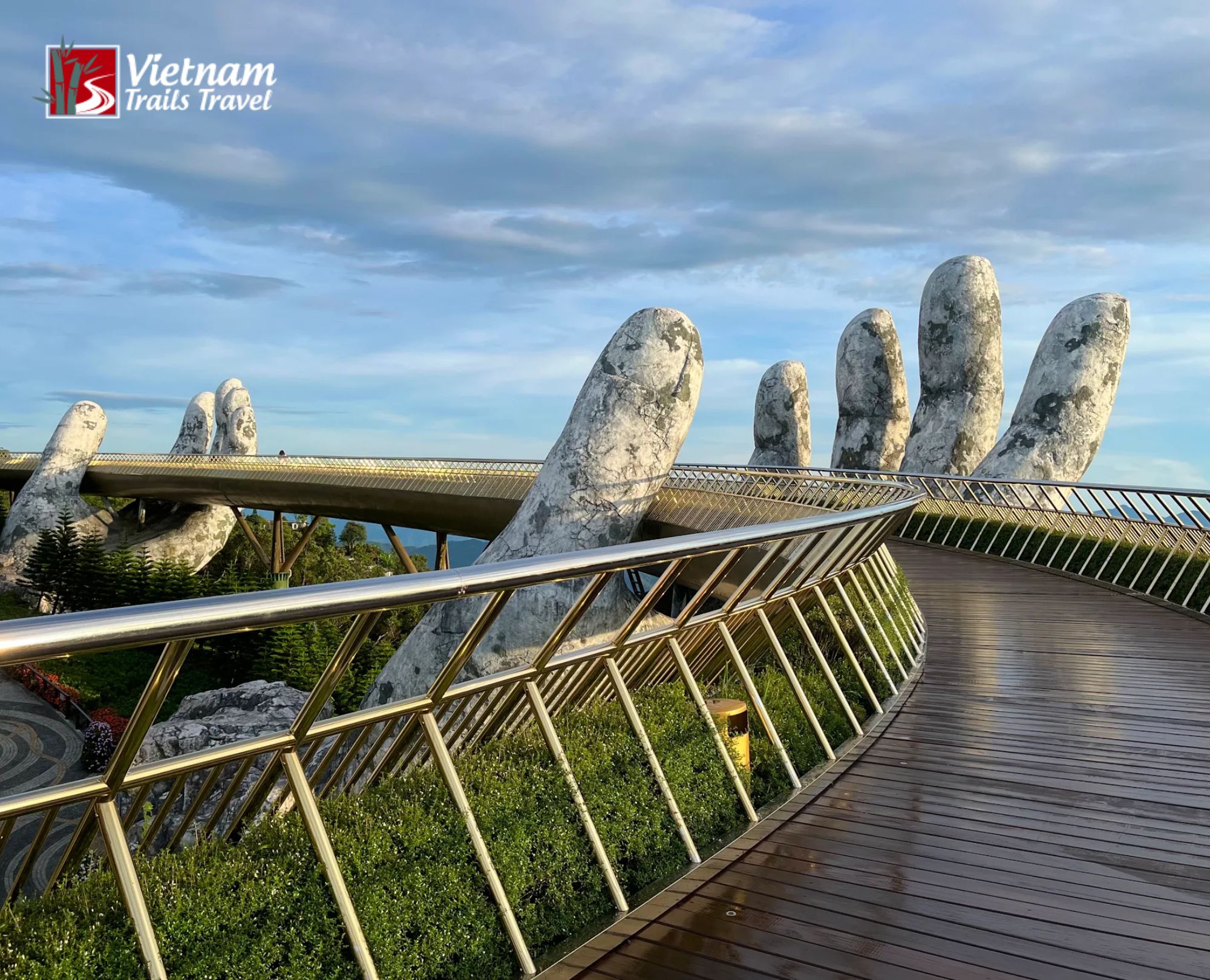 Golden Bridge Ba Na Hills Vietnam pedestrian bridge held by giant stone hands overlooking green valley