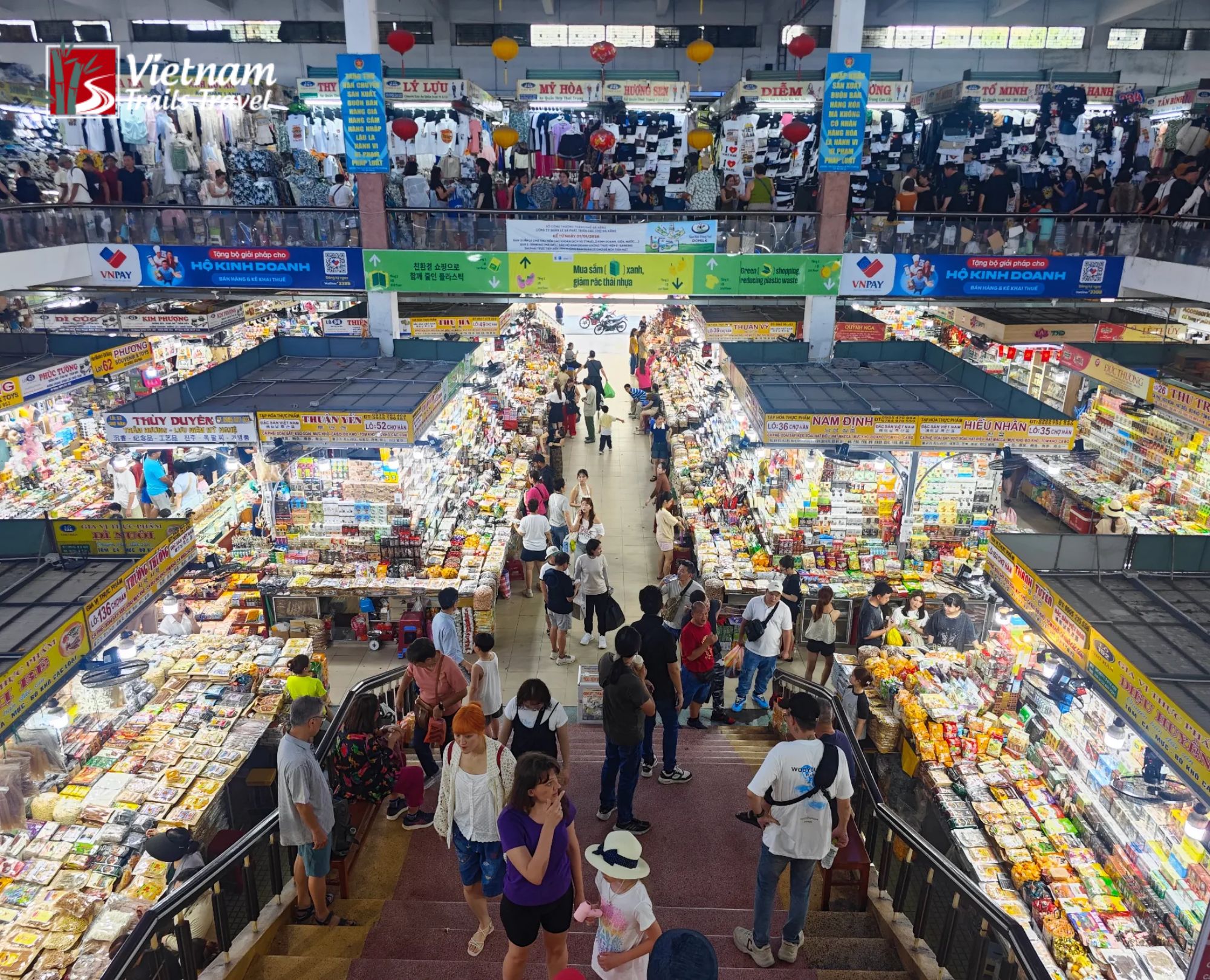 Travelers shopping at Han Market in Da Nang Vietnam captured from the upper level looking down at the busy ground floor with brightly lit vendor stalls