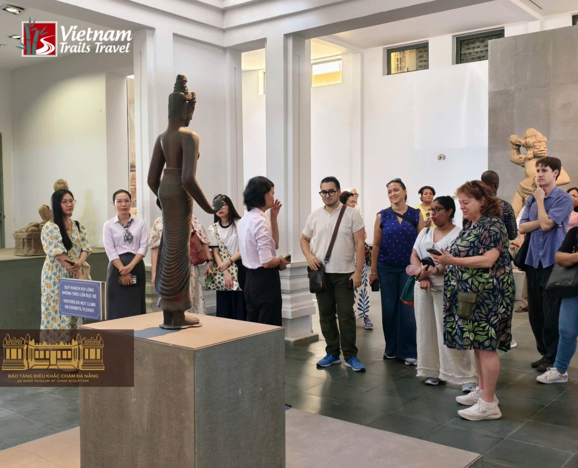 Visitors admiring a slender bronze sculpture at the Da Nang Museum of Cham Sculpture