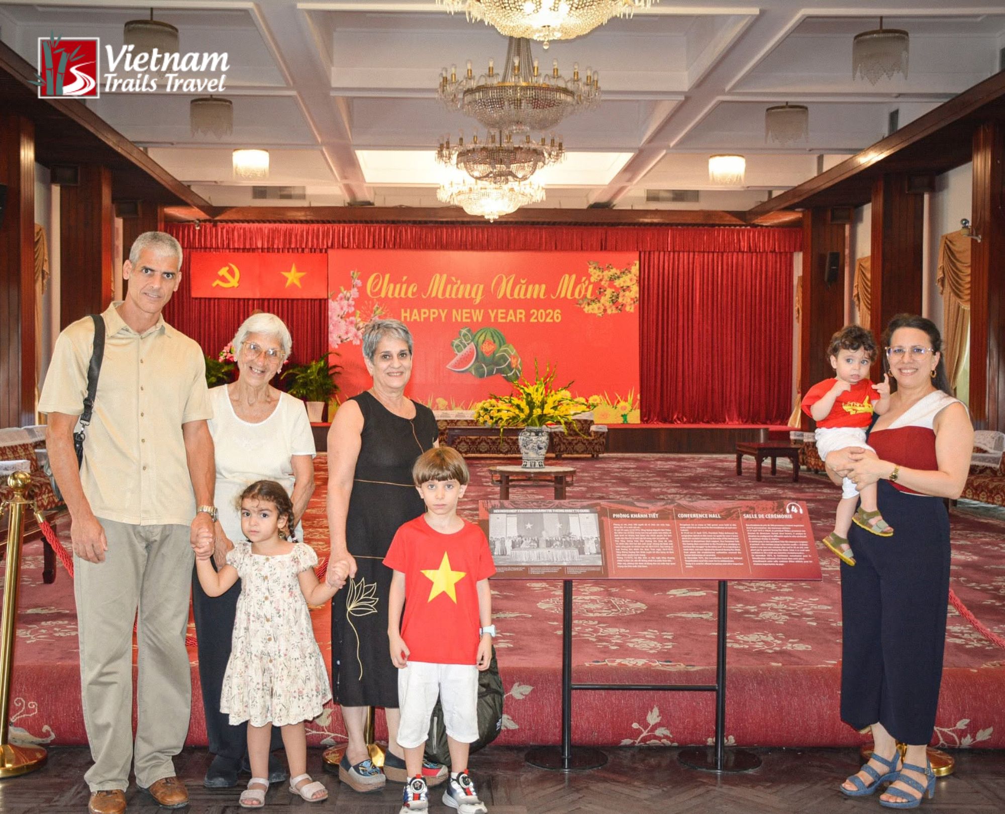 Tourists snapping a family memory in the palace museum bright space with golden chandeliers and the warm glow of the red stage