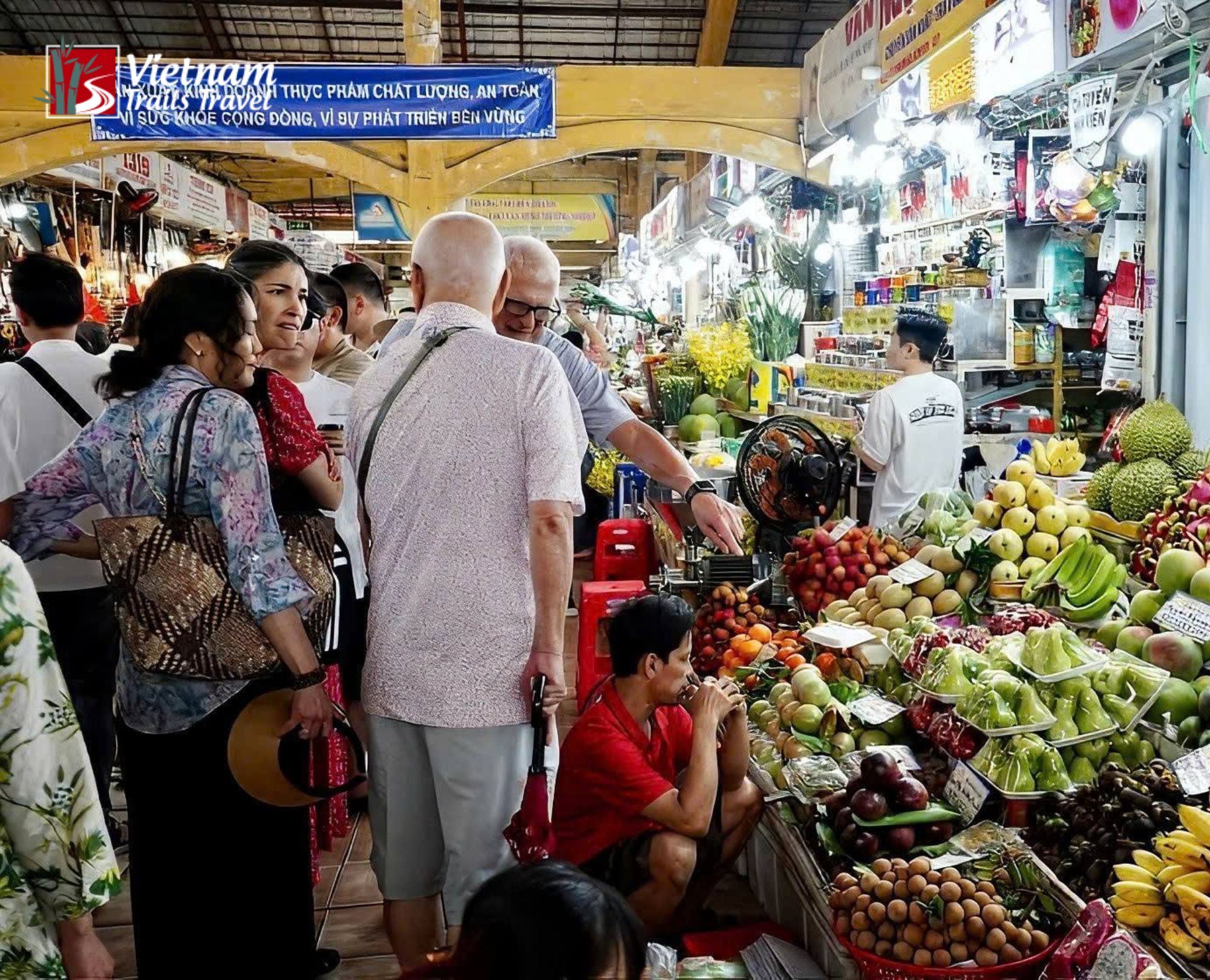 Fresh produce display and daytime market activity inside Ben Thanh Market