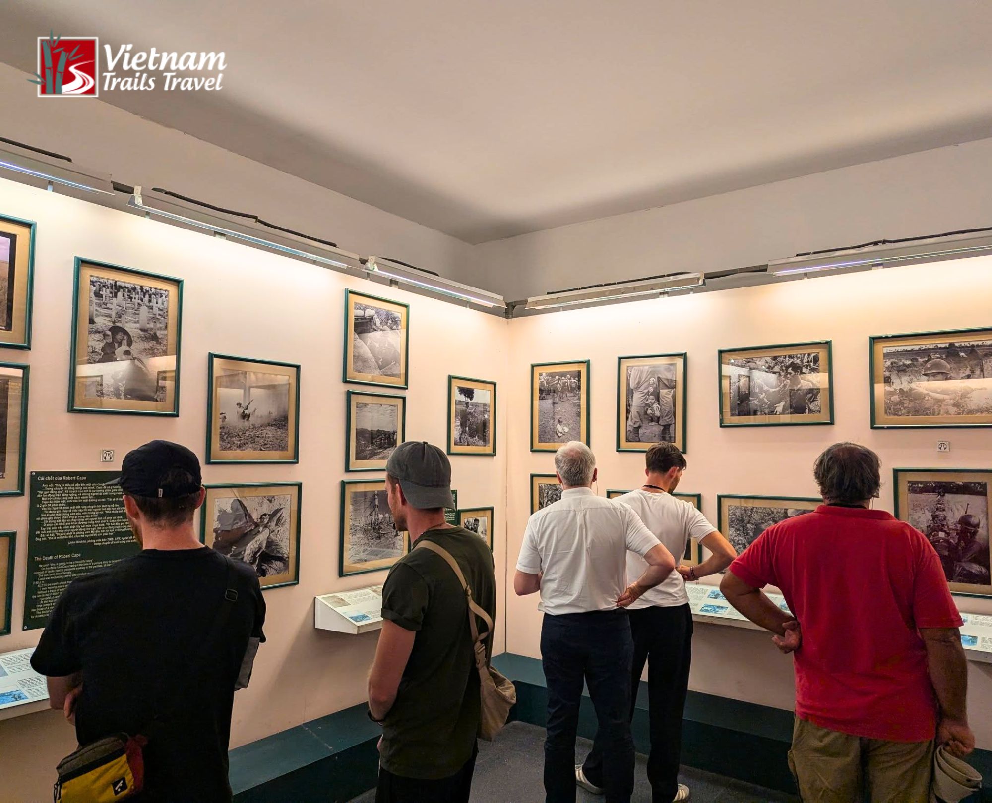 International visitors deeply engaged in reading historical exhibits, proving why the War Remnants Museum is worth visiting