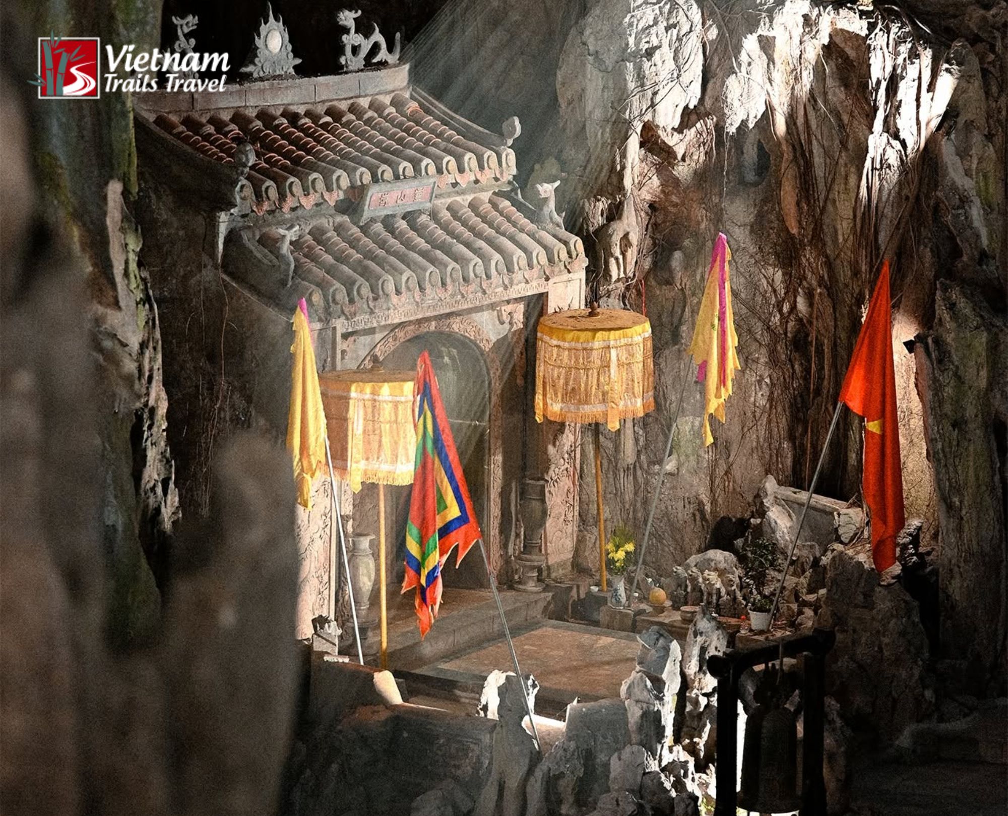 Sacred altar and traditional banners inside a Marble Mountains cave, illustrating the historical and elemental lore of the name