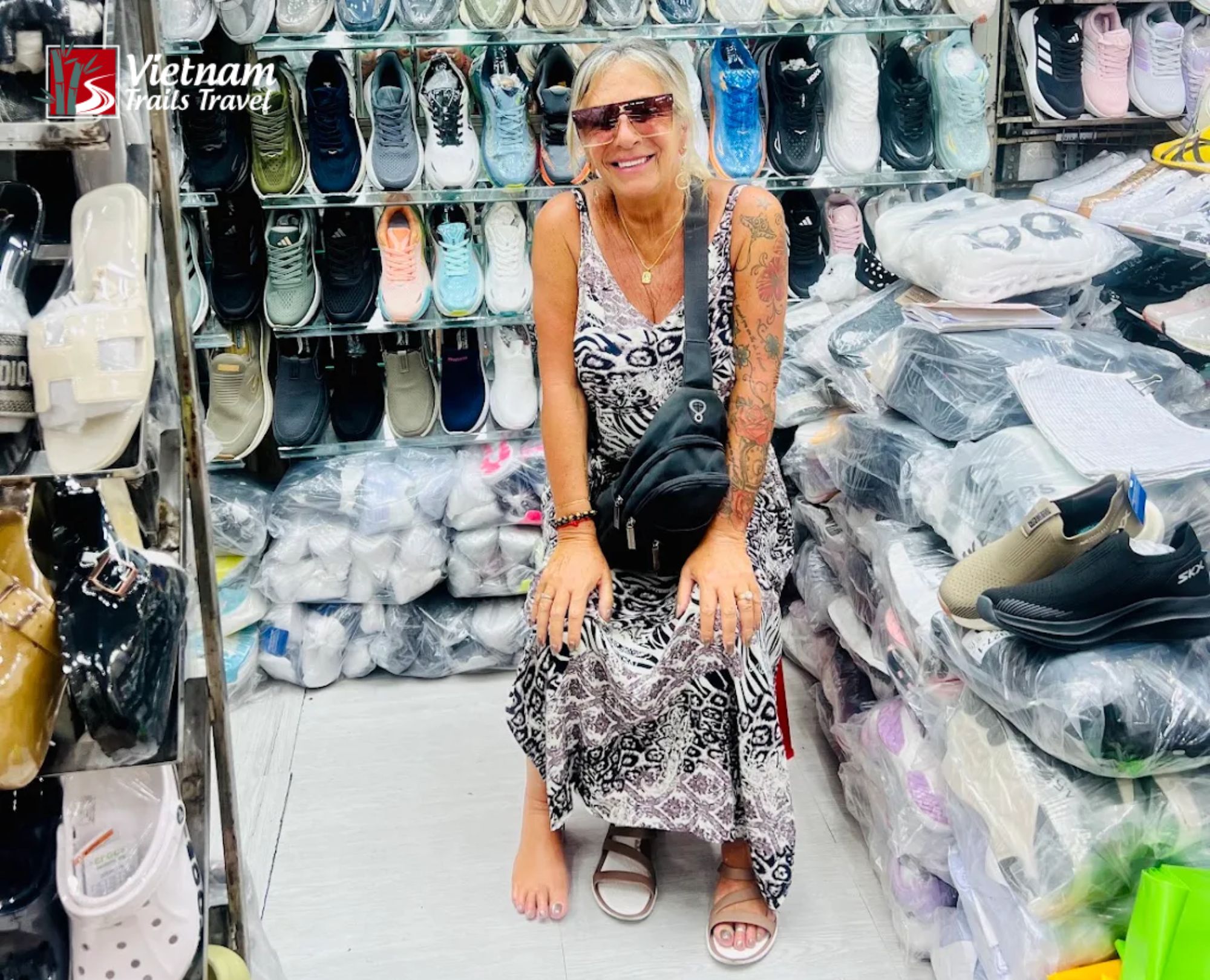 Tourist shopping and bargaining for shoes at Ben Thanh Market