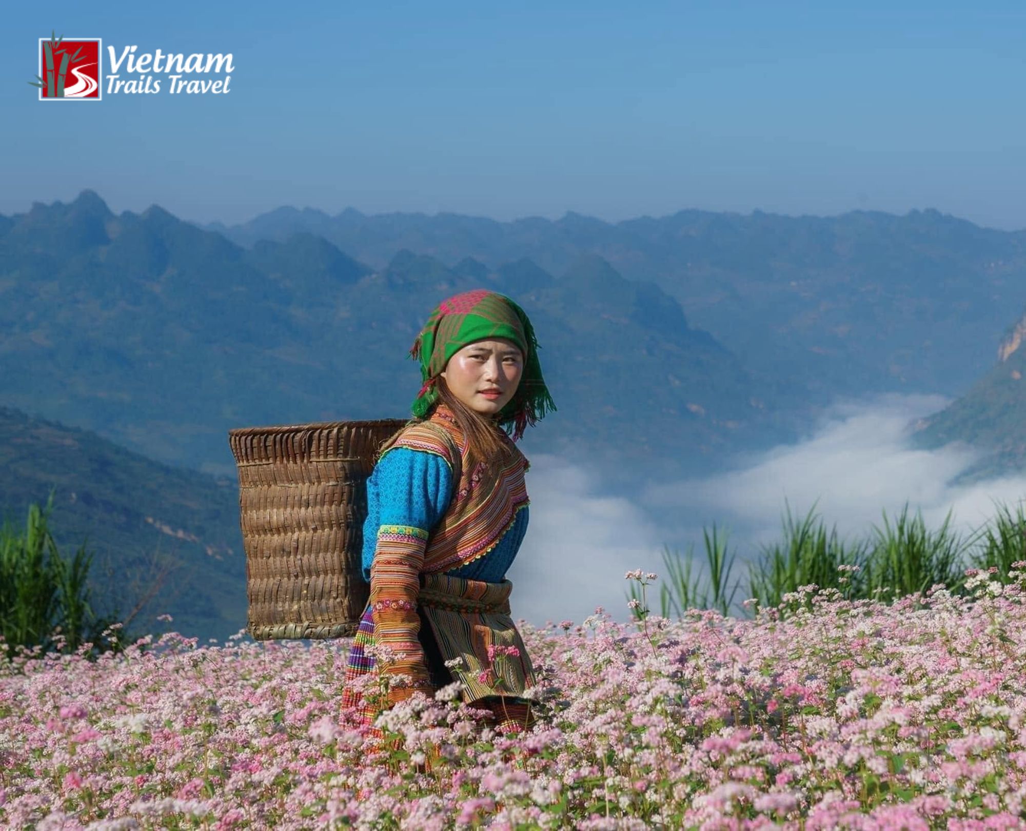 A young Mong woman in traditional dress carrying a back basket on her way to work in the mountains