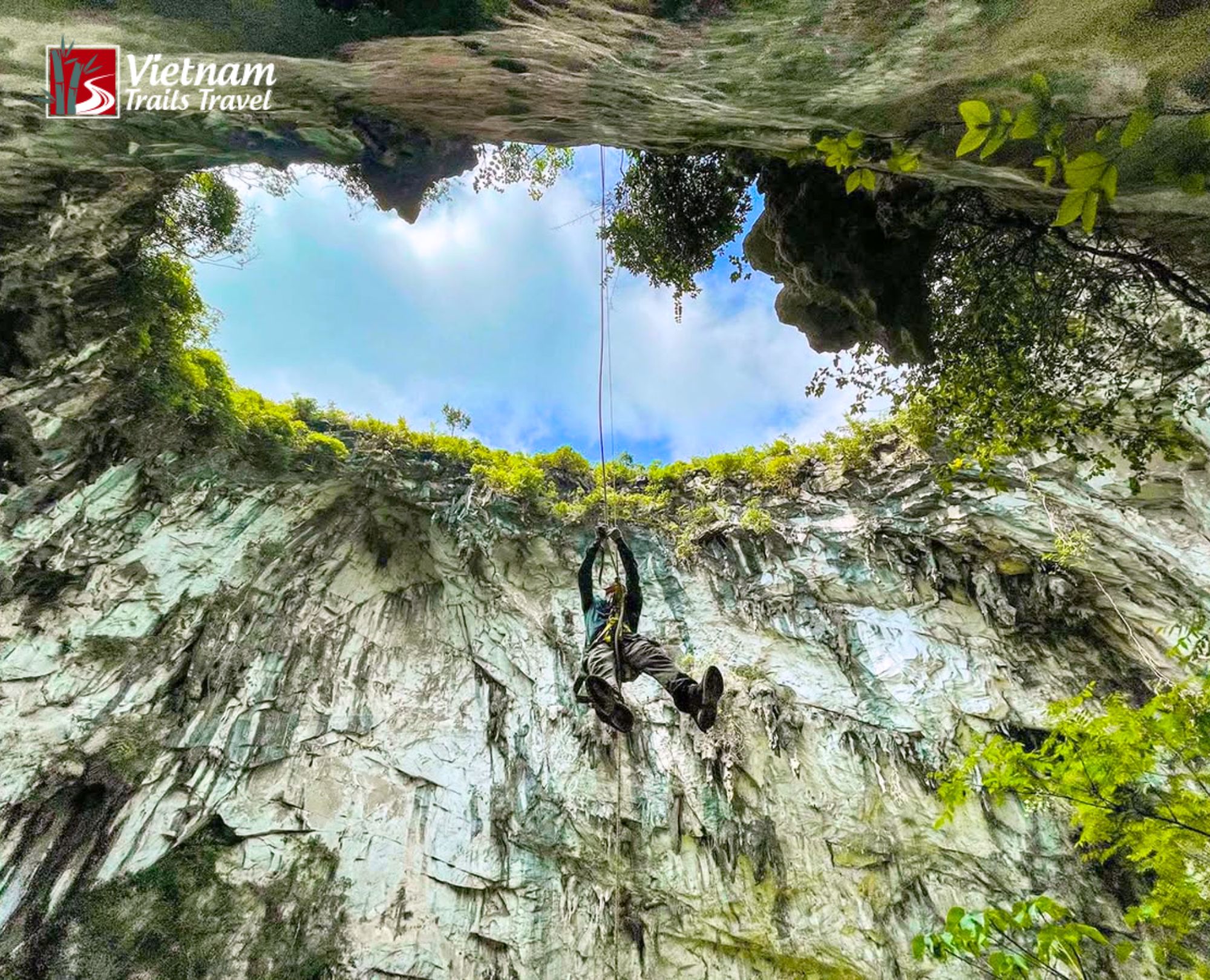 Adventurer rappelling down a rope into Meo Vac Sinkhole cave
