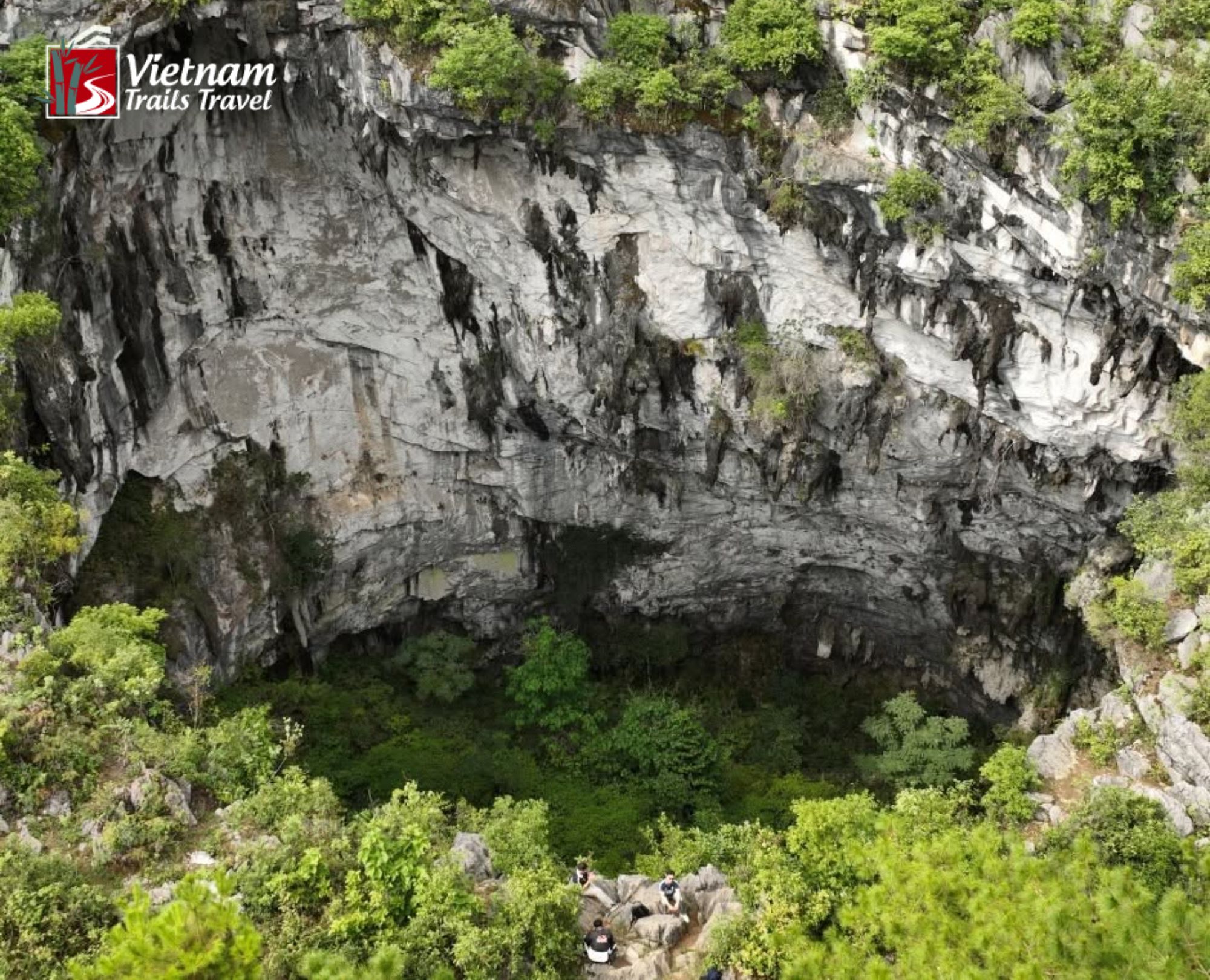 Aerial view of Meo Vac Sinkhole with lush green vegetation and rocky walls