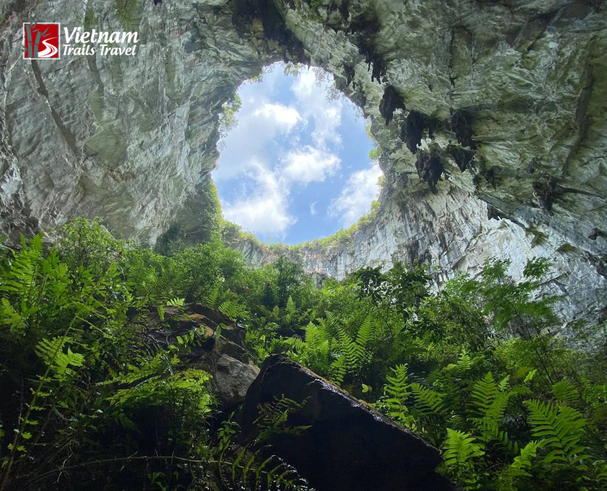 Bright sky visible through the round top of Meo Vac Sinkhole in Ha Giang