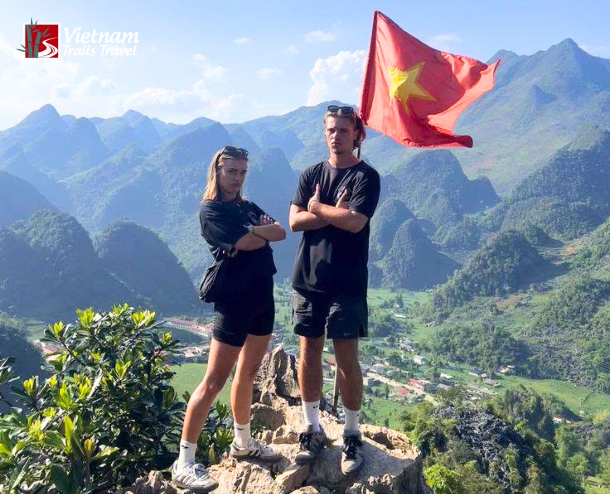 Conquering the heights with breathtaking valley vistas unfolding behind a proud travel duo in Yen Minh