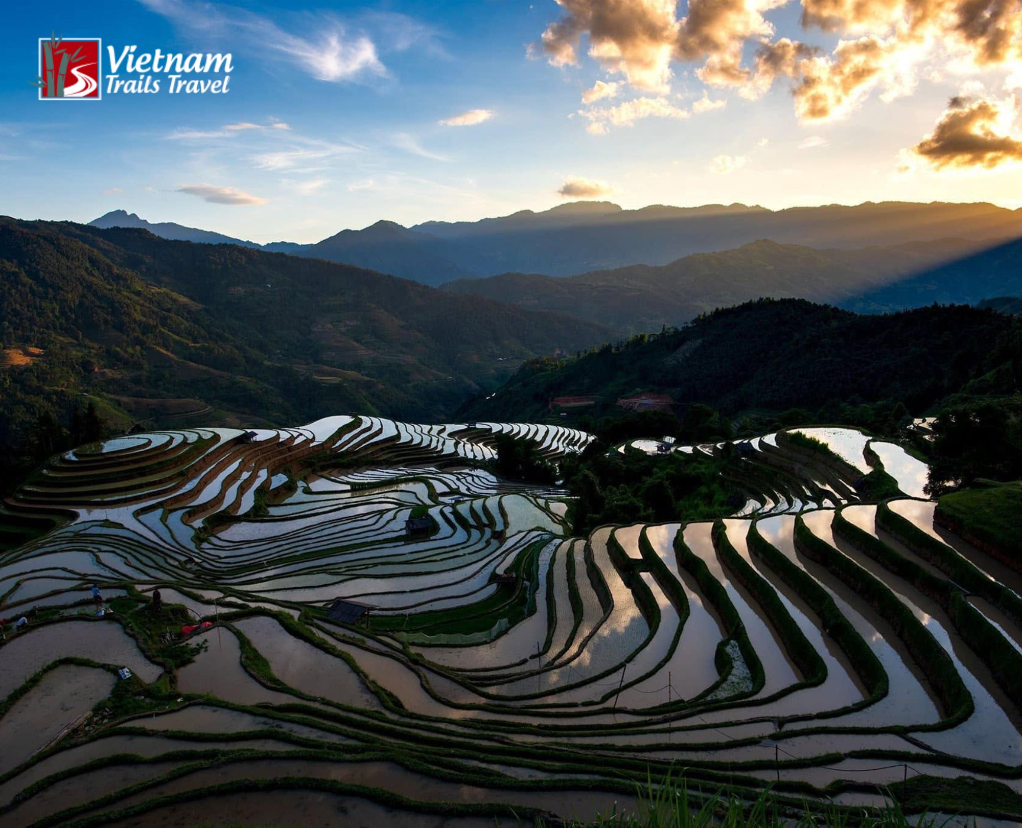 Flooded rice terraces in Thong Nguyen and Nam Ty, curving around green hills beneath a dramatic evening sky