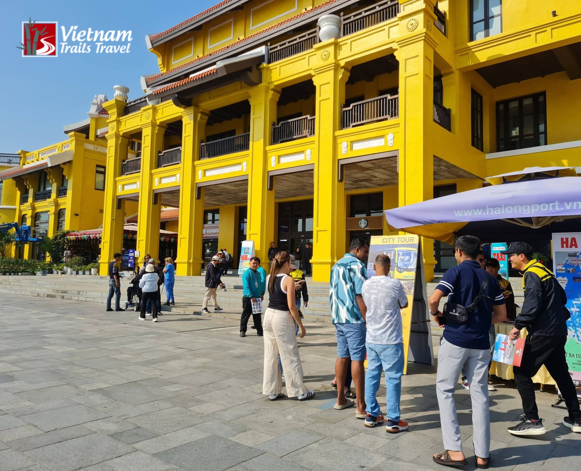 Halong Port terminal square filled with tour groups on a clear sunny morning