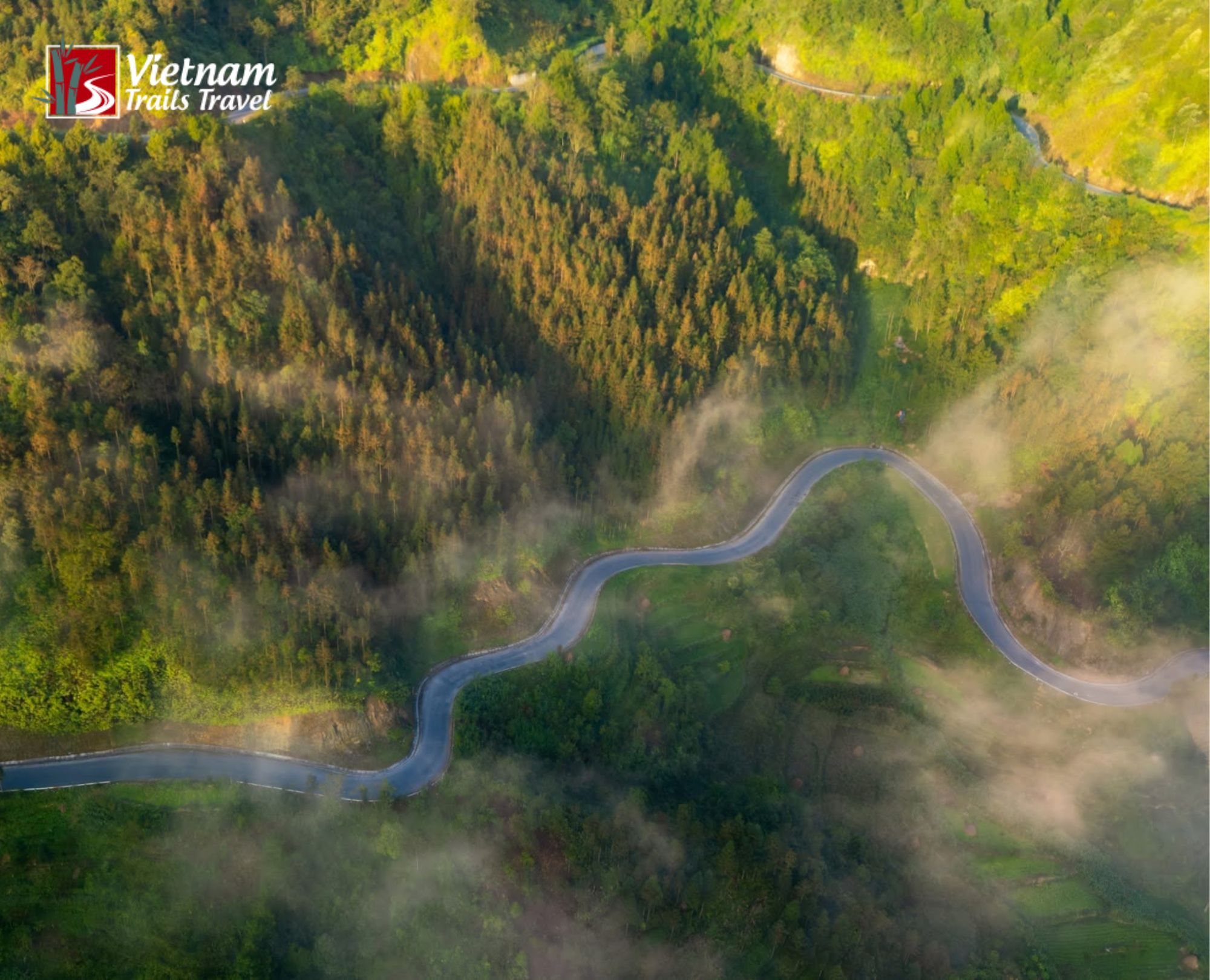 Mist drifts across the winding Du Gia road as sunlight touches the wooded hillsides