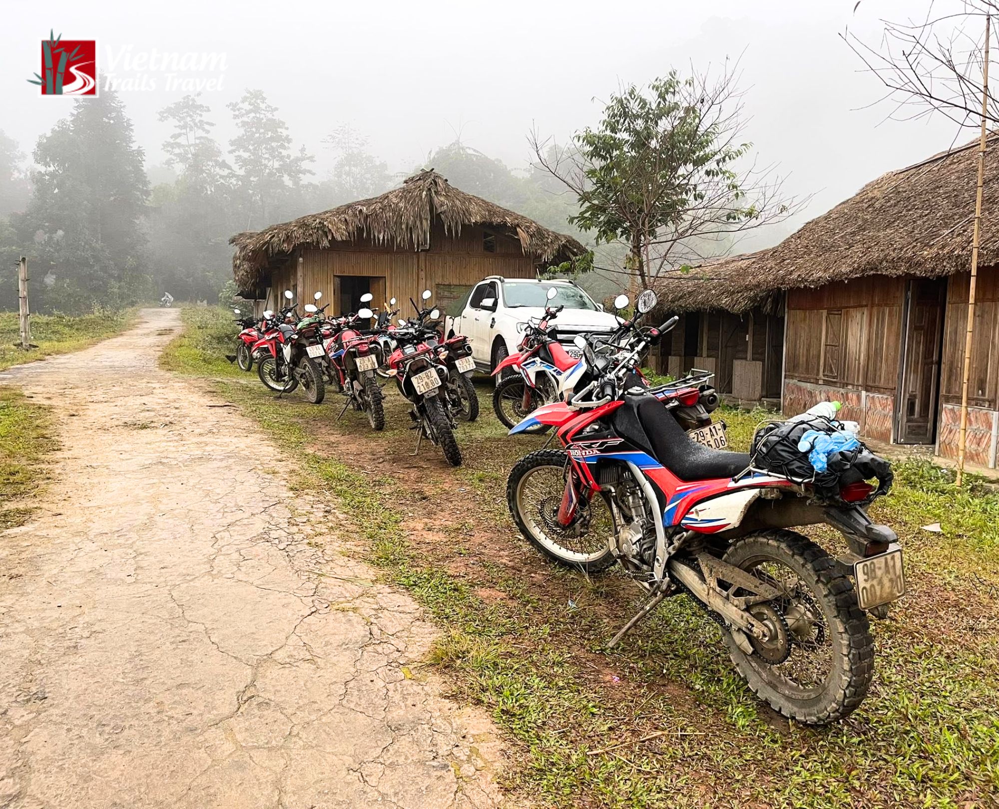 Motorbike travel in rural Hoang Su Phi, with a loaded Honda dirt bike before misty tree covered hills