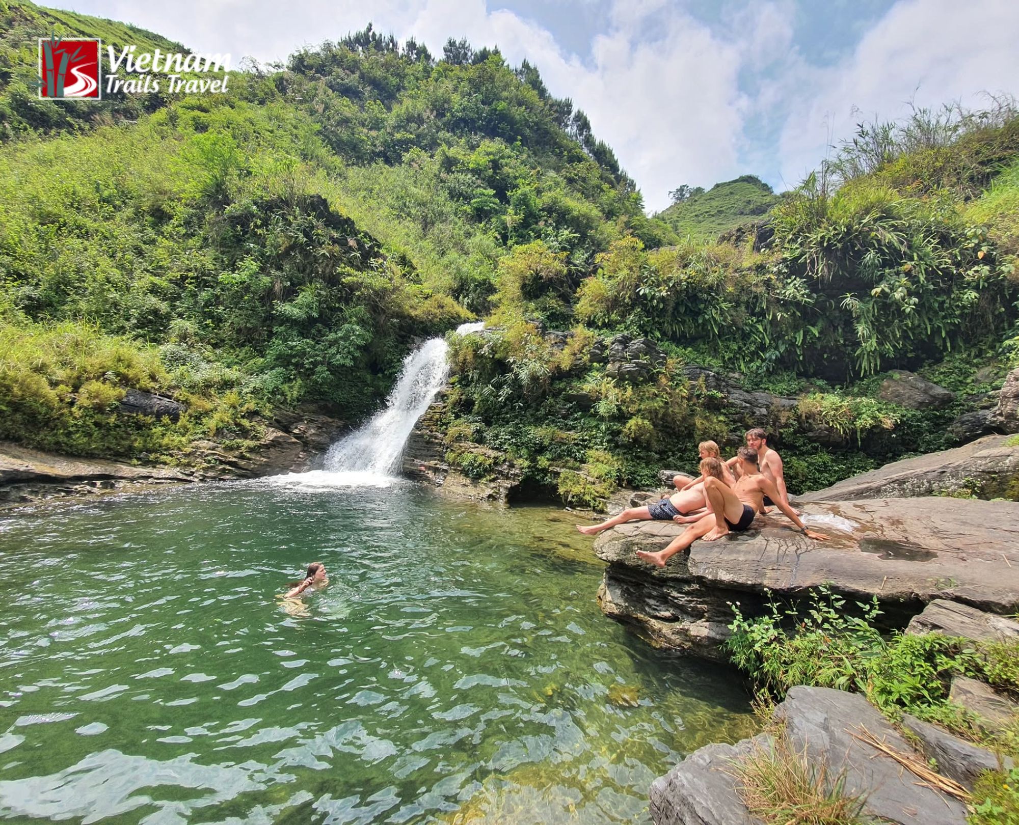 Relaxing moment by the clear green stream and waterfall in the lush green nature of Du Gia