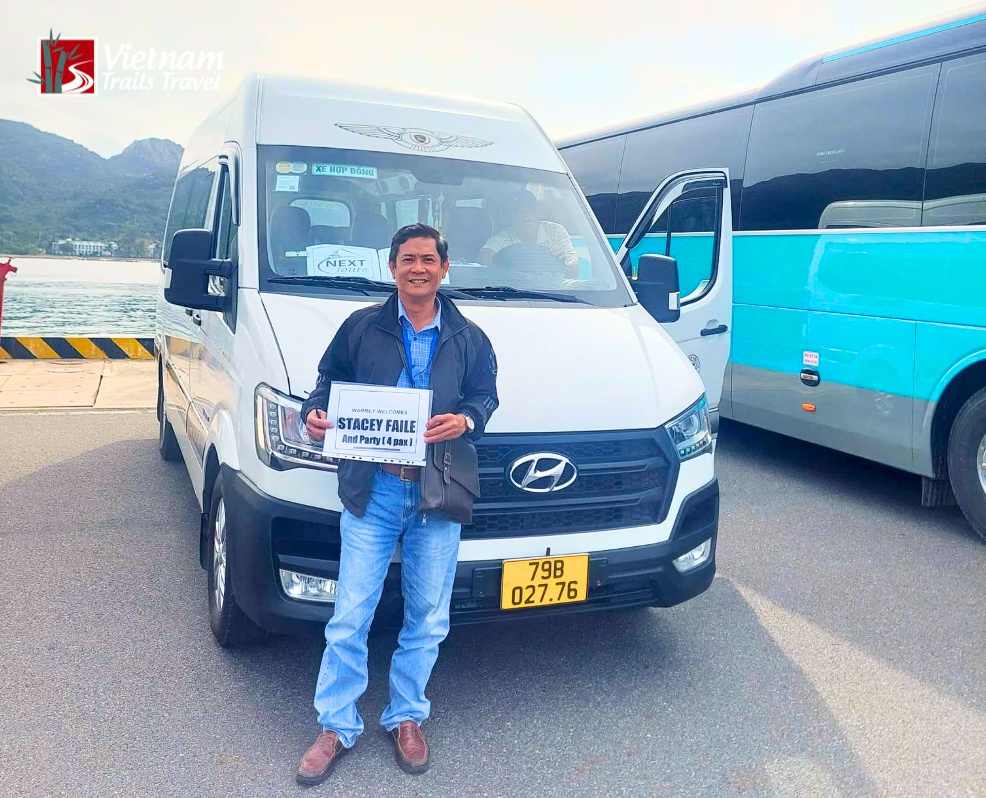 Smiling driver waiting beside a white minivan to pick up passengers on a Nha Trang shore excursion at Cam Ranh Port