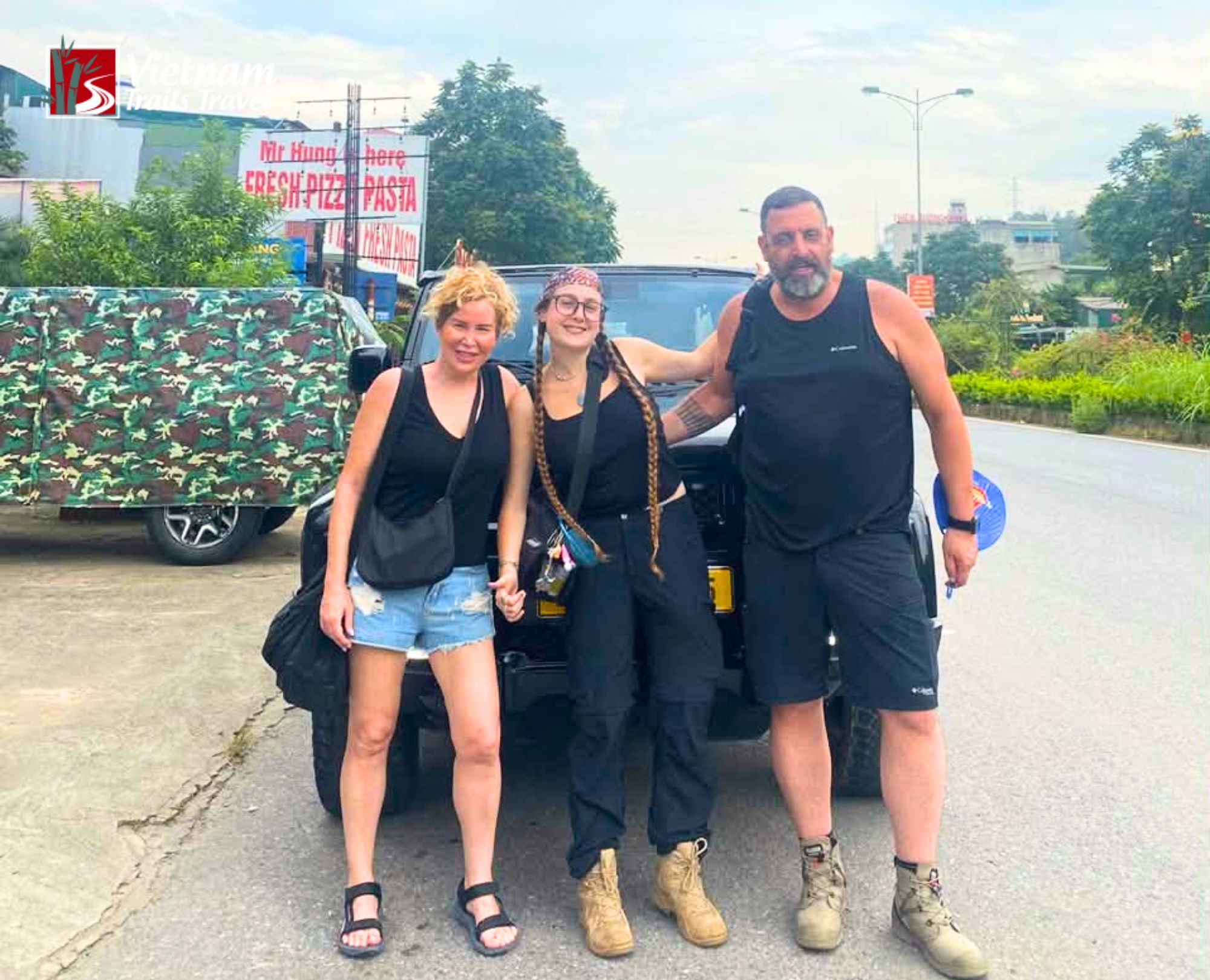 Tourists ready for adventure standing beside a tour transport vehicle in Vietnam