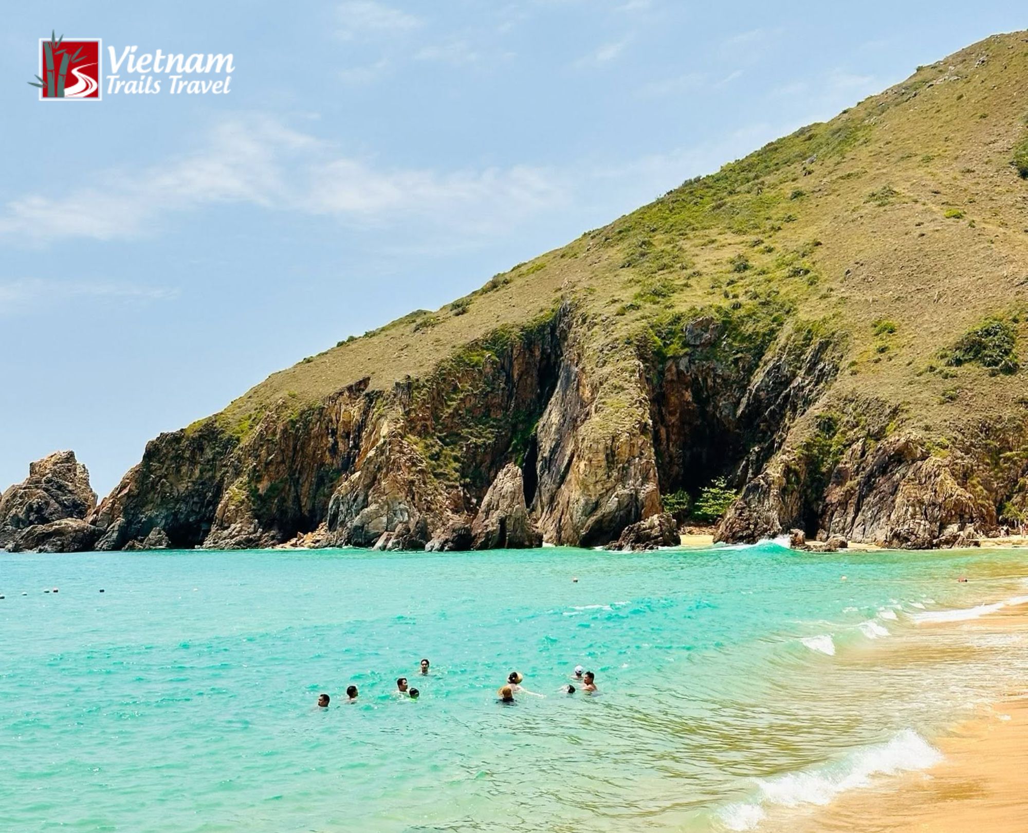 Tourists swimming in the crystal clear turquoise water at pristine Ky Co Beach