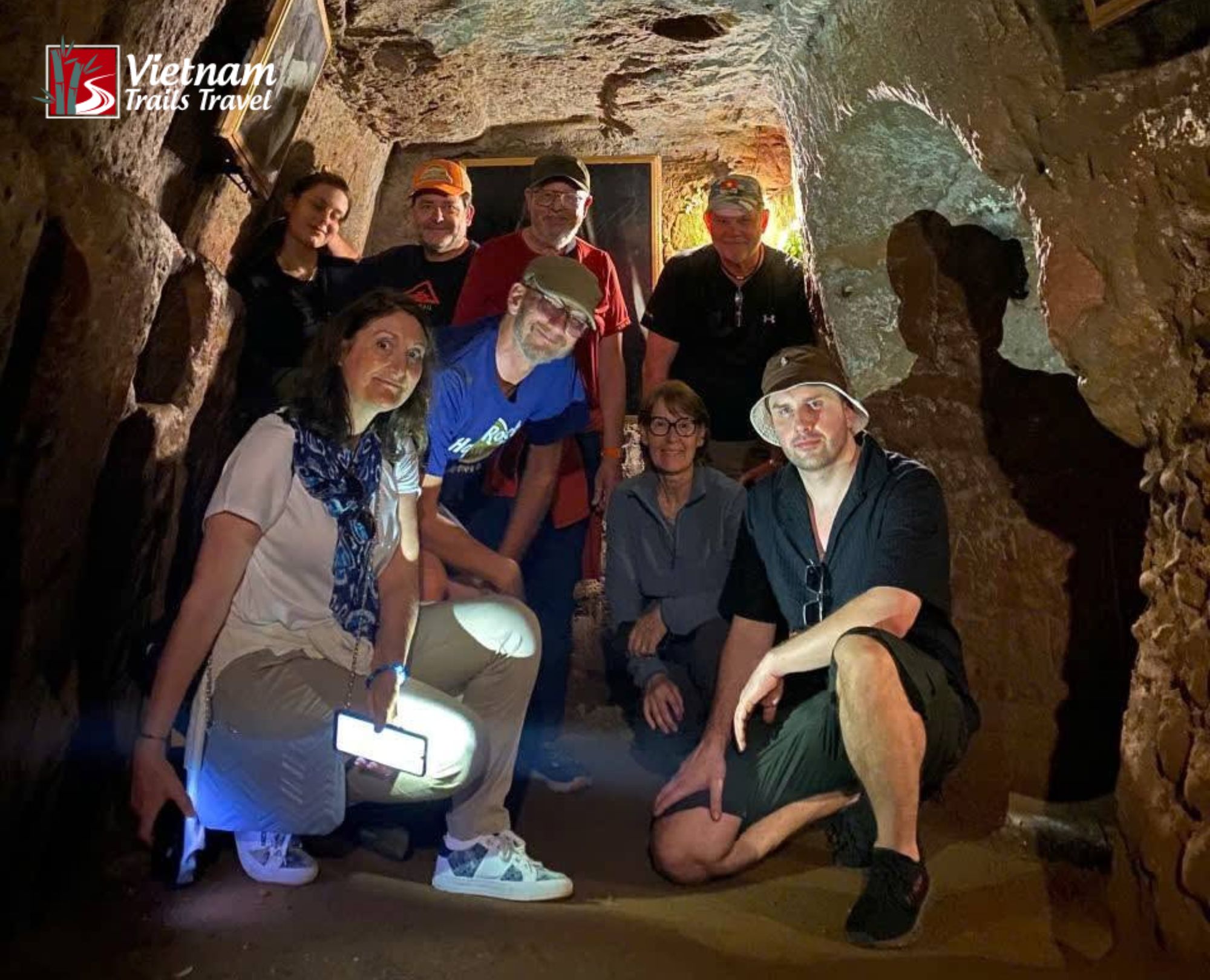nside the historical underground network at Vinh Moc Tunnels a group of international visitors poses together